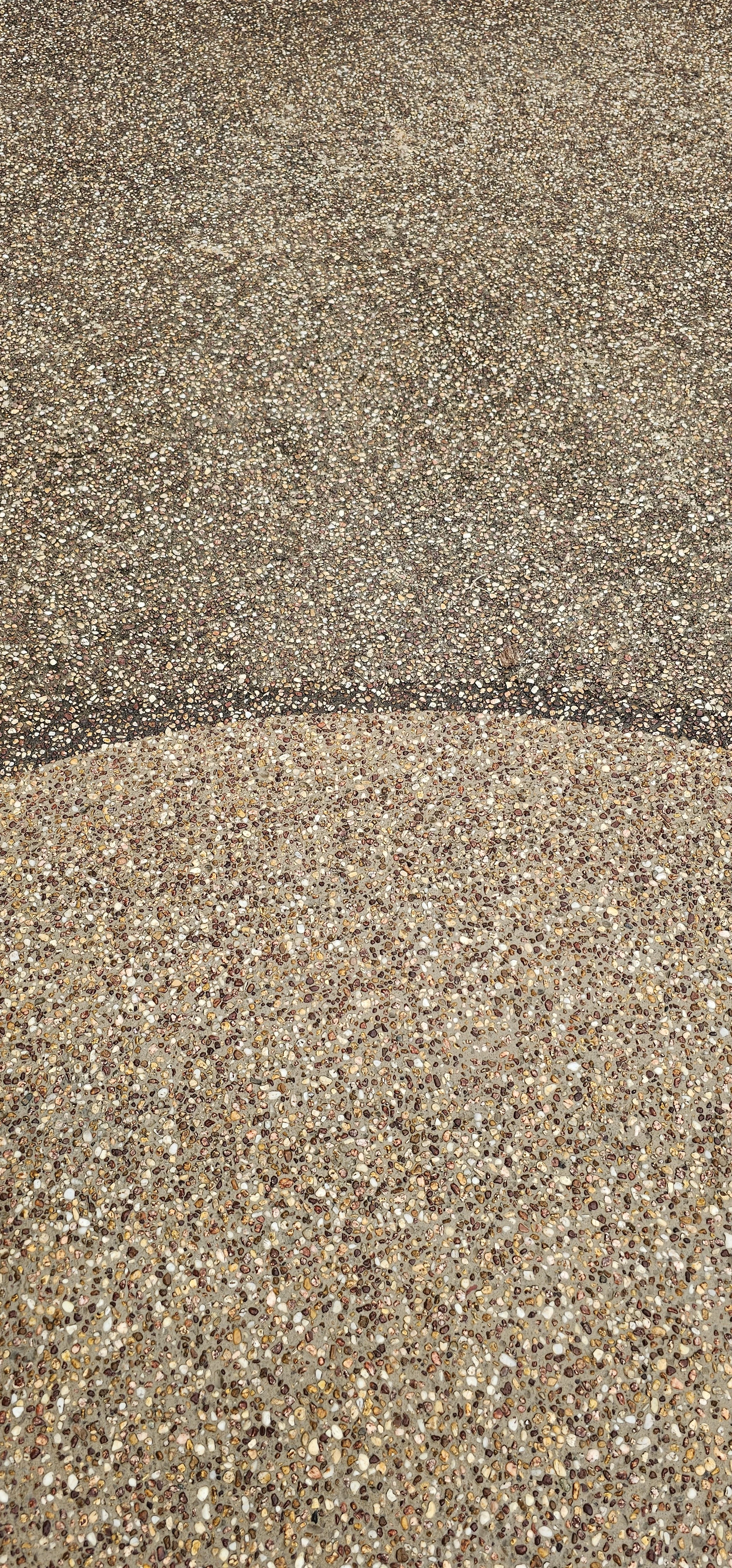 Close-up of two different textured pebble surfaces, one darker and one lighter.