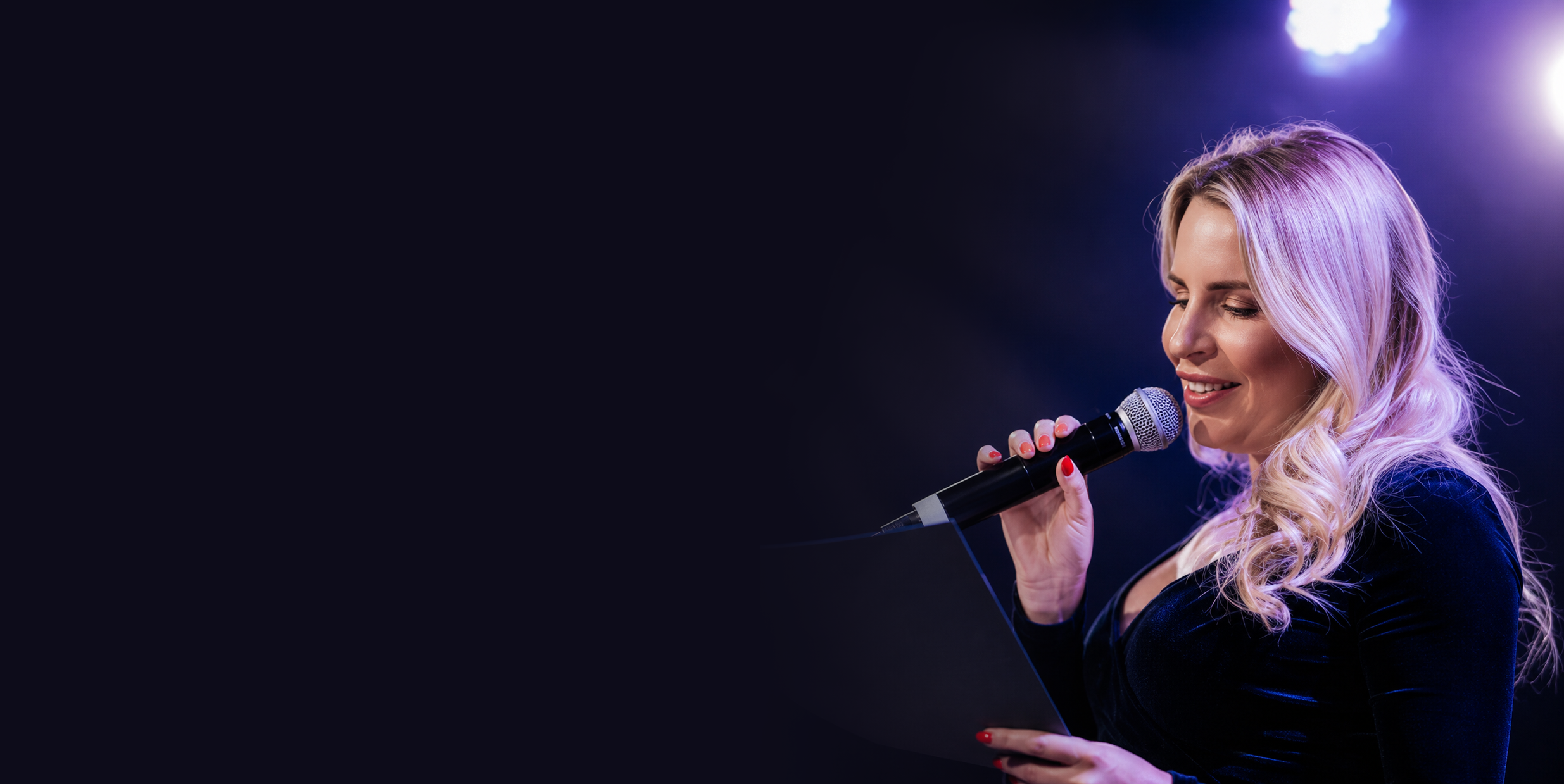 Olympia Kwitowski speaking into a microphone on stage