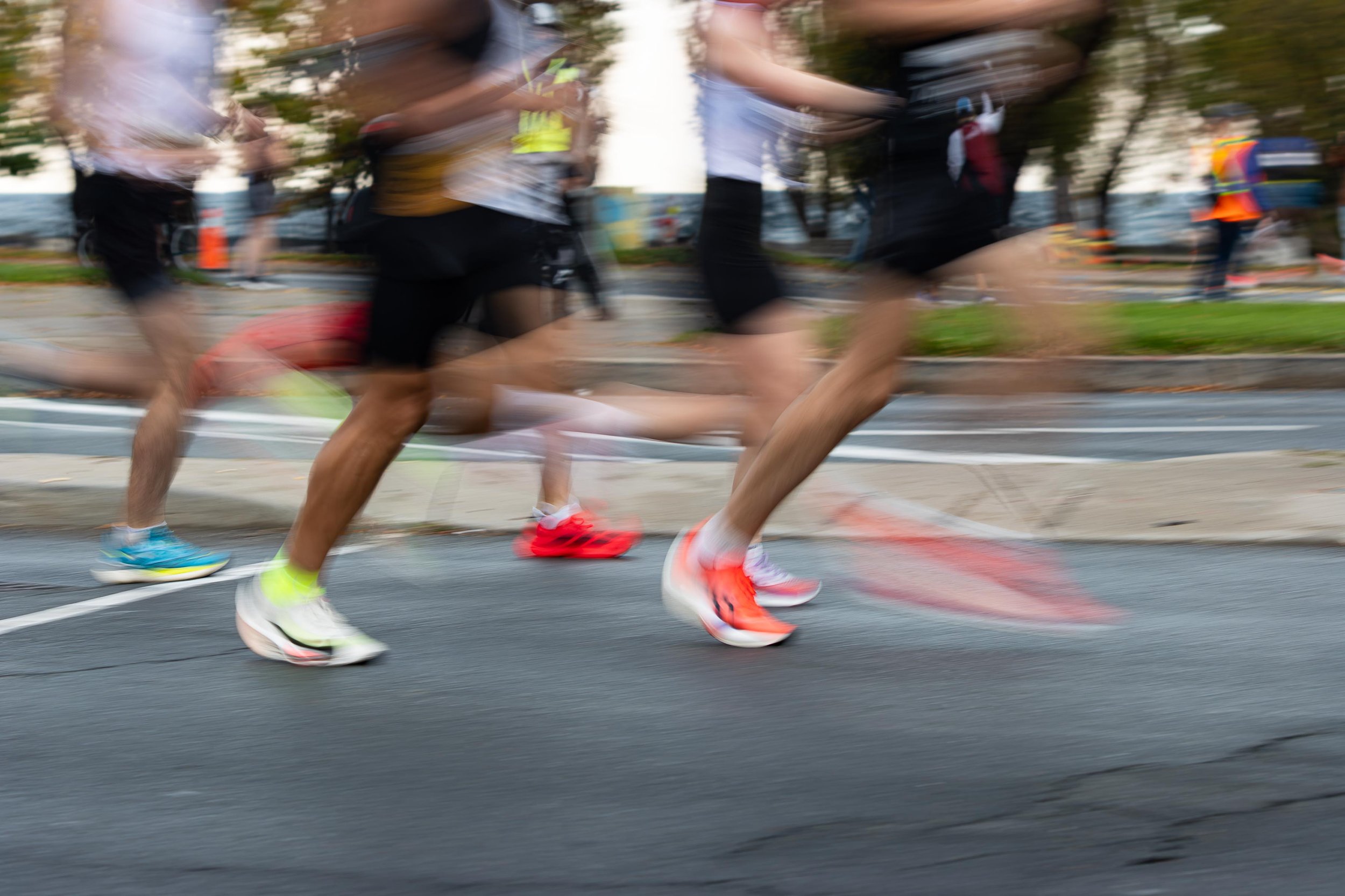 Blurry motion of marathon runners' legs and shoes during a race.
