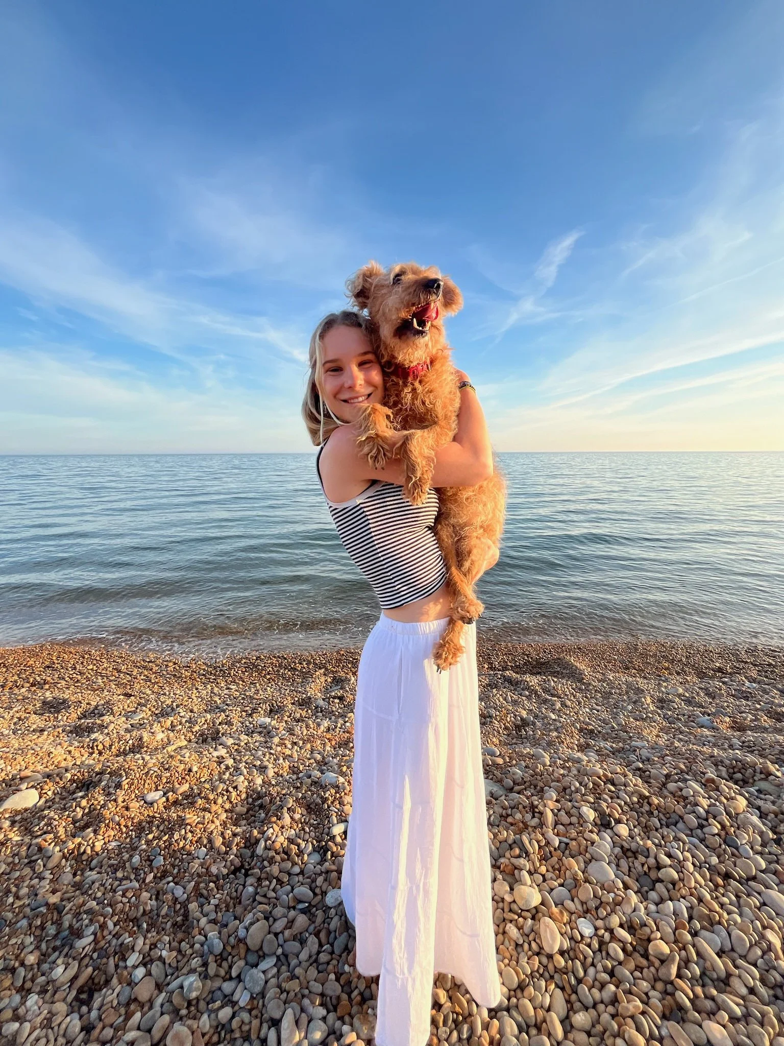 Bridge House girl holding dog on beach at UNESCO Jurassic coast