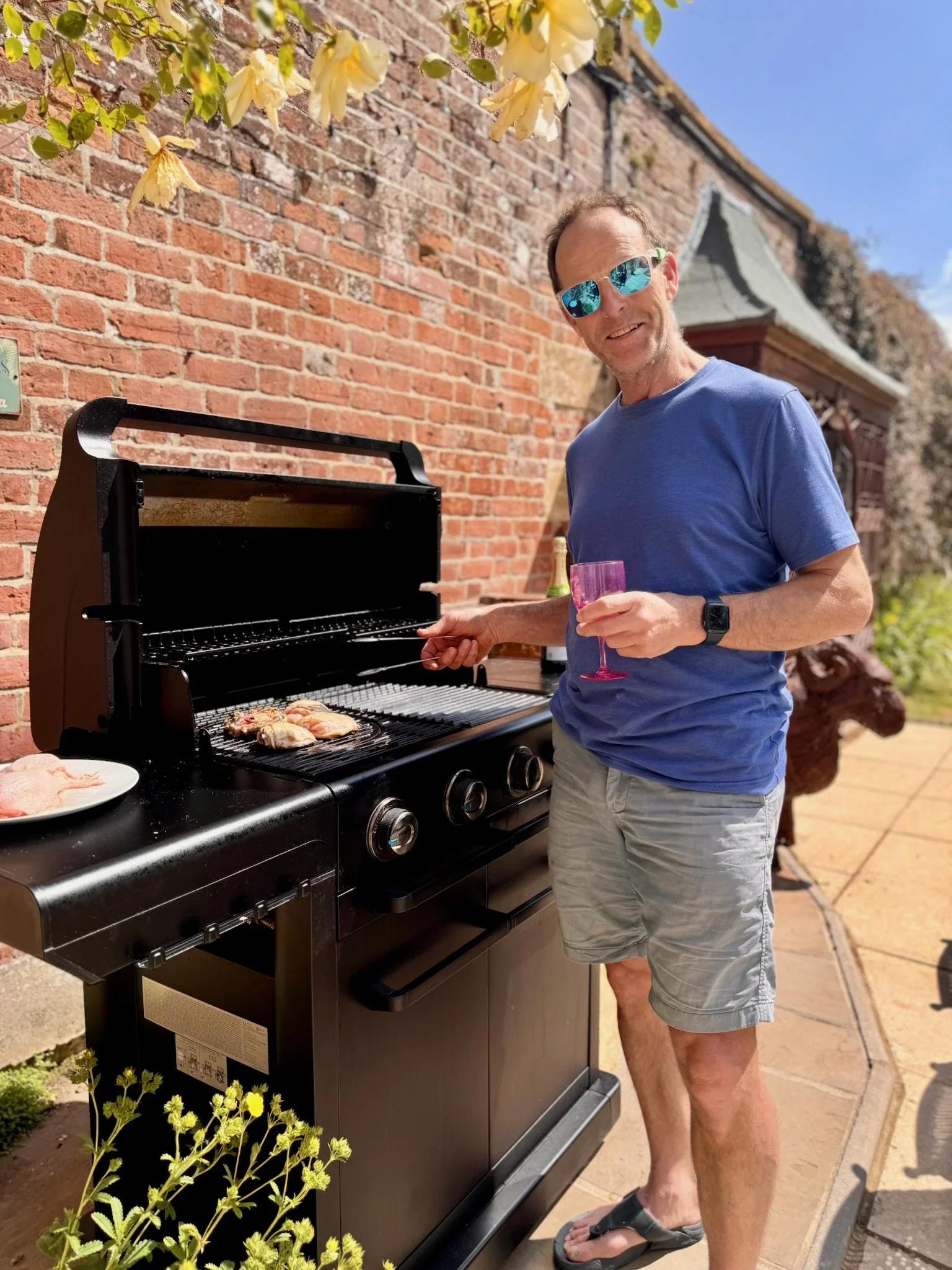 Bridge House cooking on large gas BBQ for multigenerational lunch on terrace