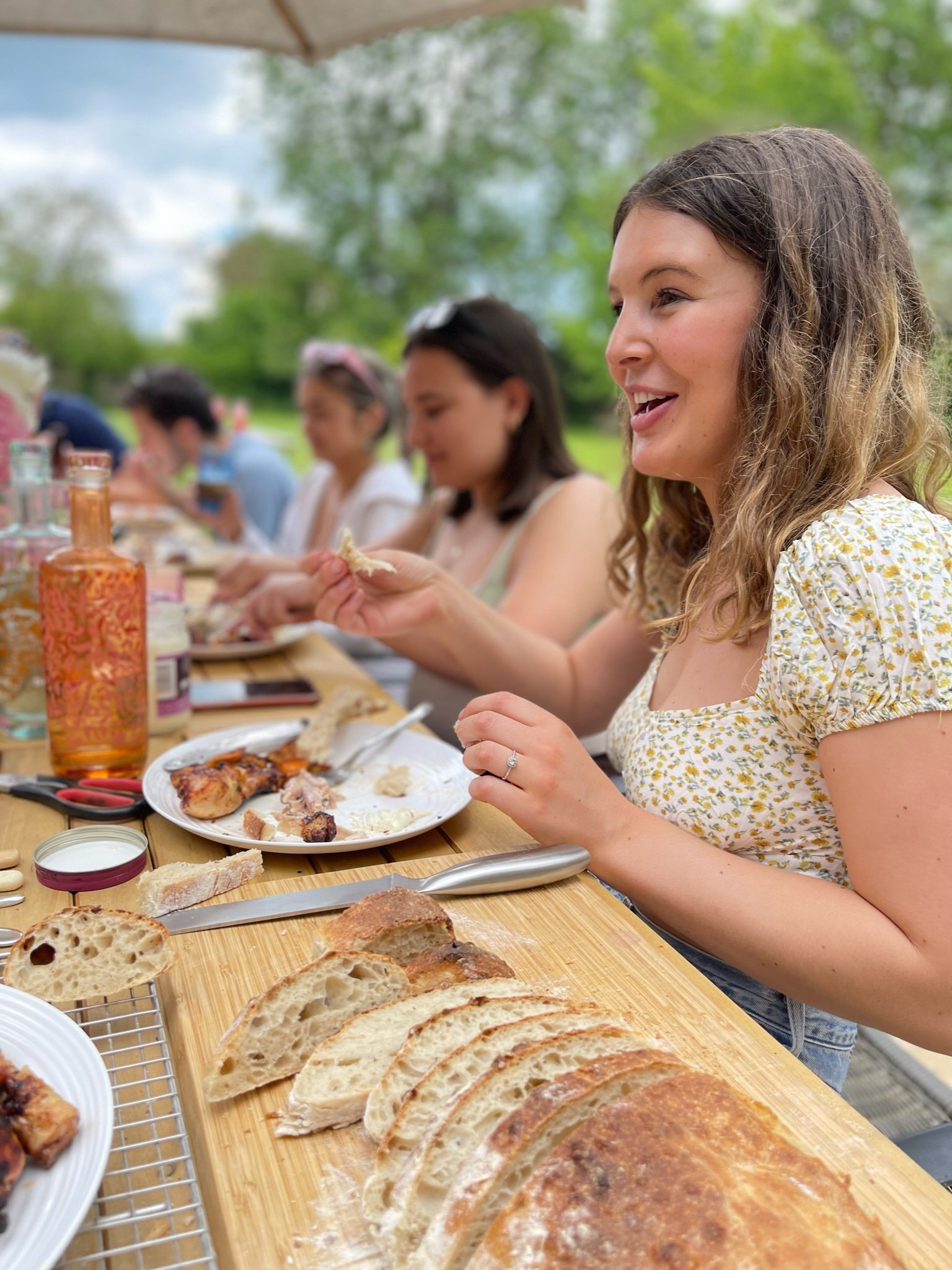 Bridge House Somerset - Group of friends eating around the outdoor table on the patio.