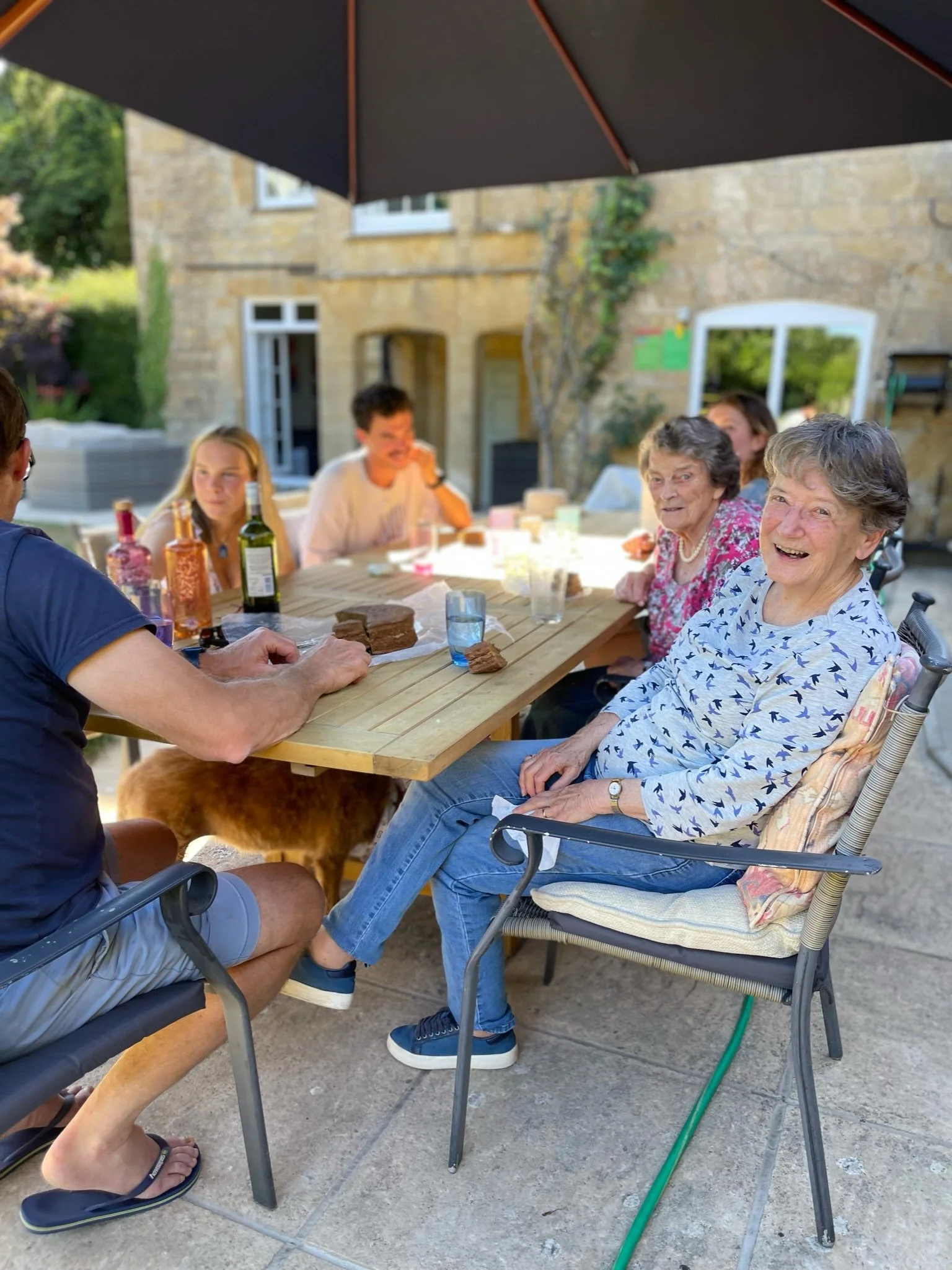 Bridge House Somerset - Multi-generational family group eating around table near the heated pool