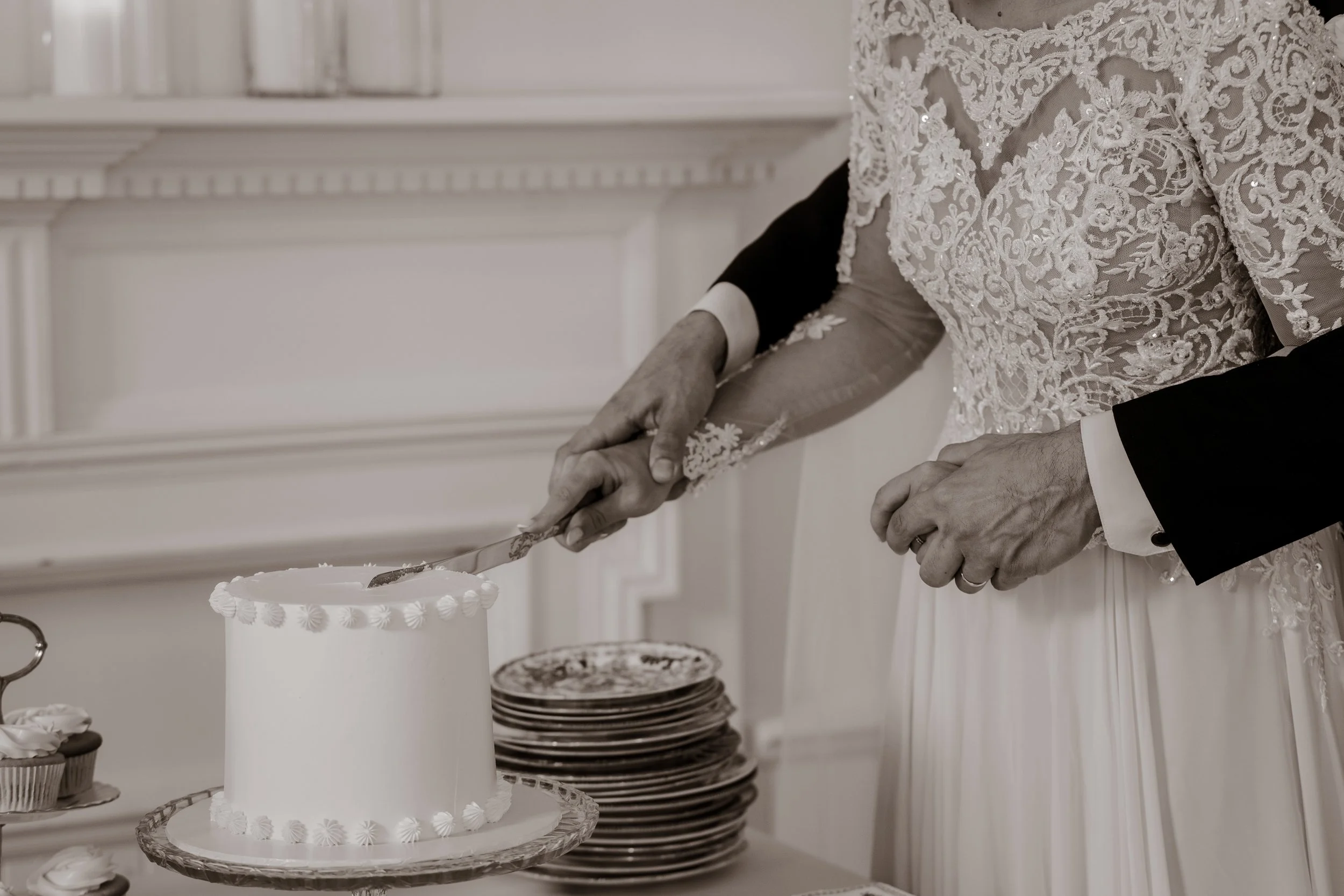 A bride and groom cutting their wedding cake together at a reception.