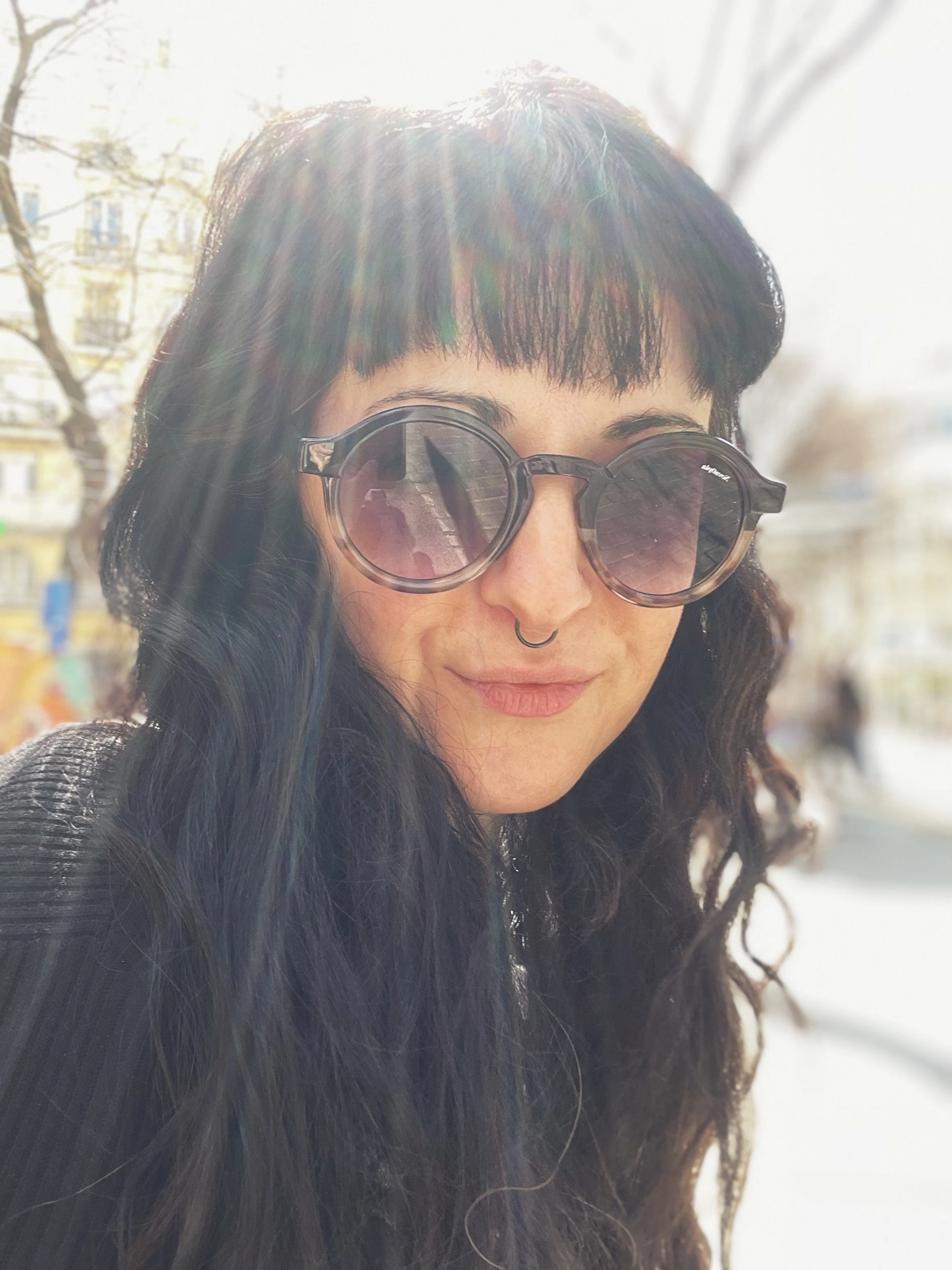 mujer morena con flequillo y gafas de Sol redondas