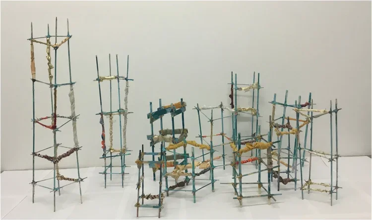 "Refuge" by Laurie LeBreton, 13 sculptures 6" to 18", high wooden dowels, handmade paper, fabrics, acrylic paint