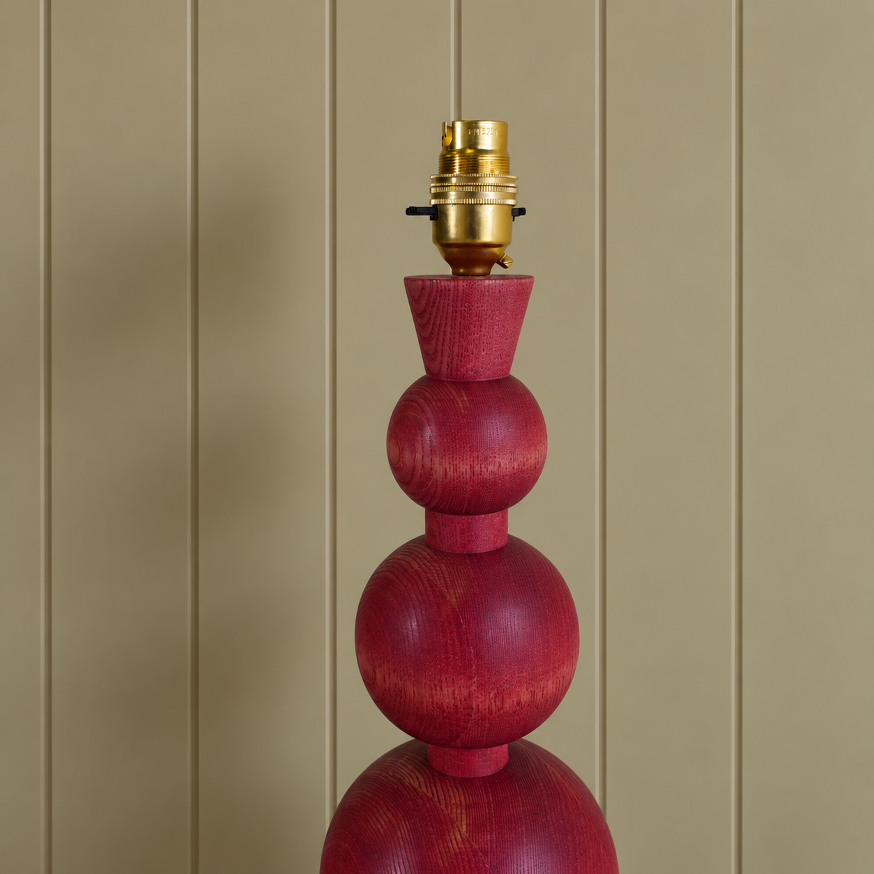 Cropped Burgundy Wood Lamp Base Against Paneling.png