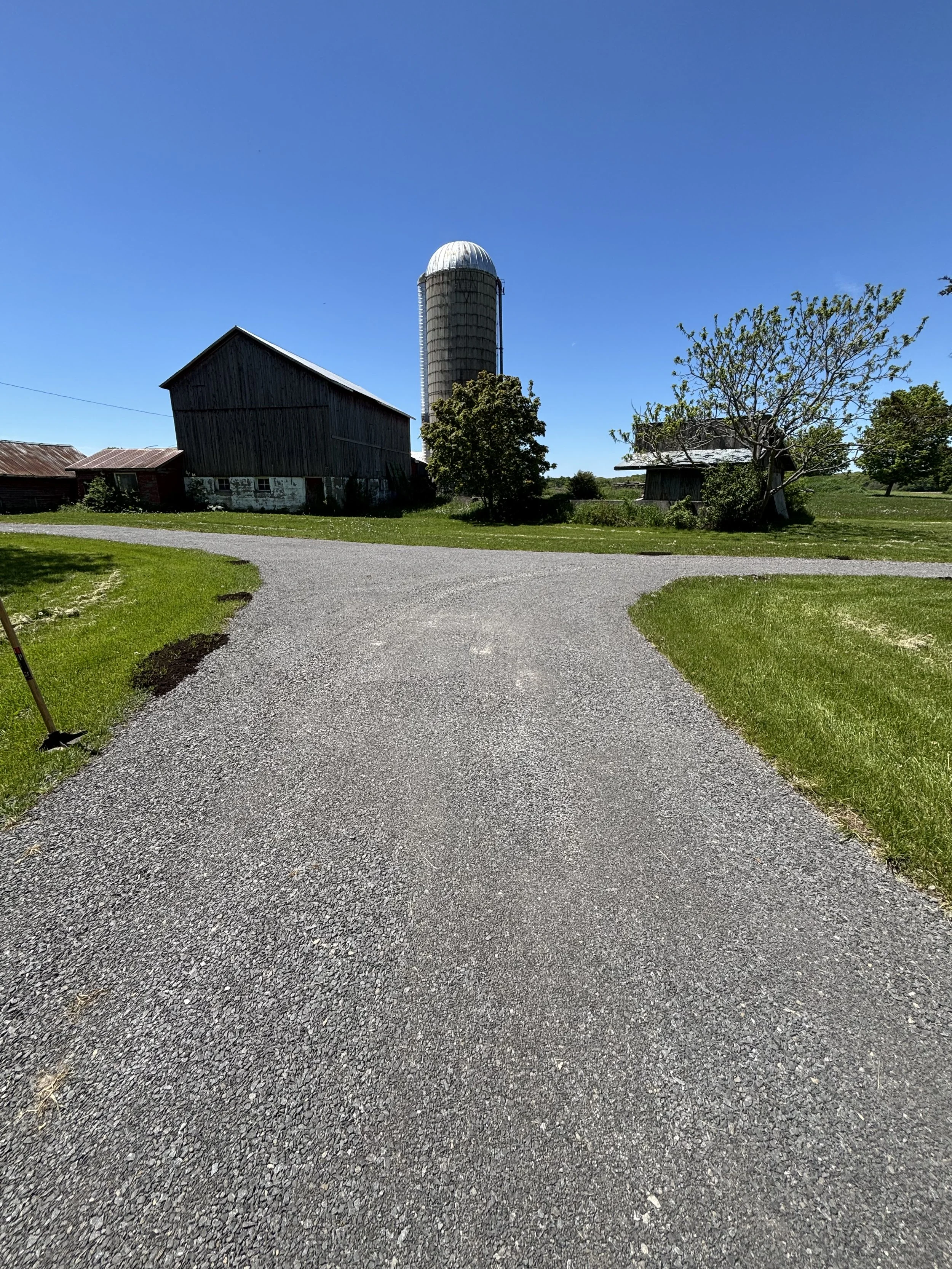 When we arrived this section of gravel driveway was more of a lawn than a driveway.  We removed the overgrowth down to the original base, and built back up with 5/8ths gravel from there!