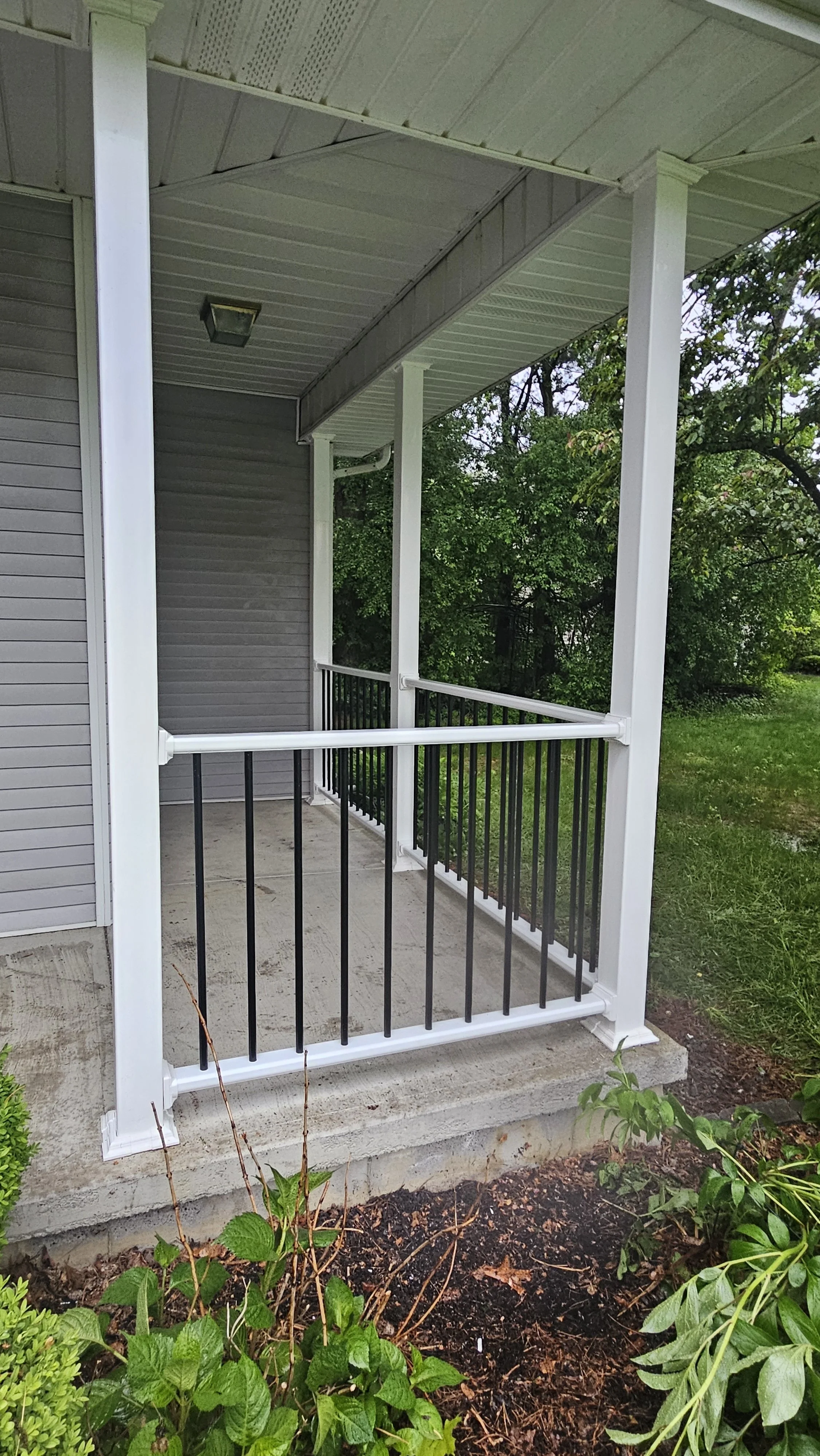 Completed porch rebuild with new posts, railings, stairs, and black metal spindles for a stronger, cleaner, modern, more updated front entry. 