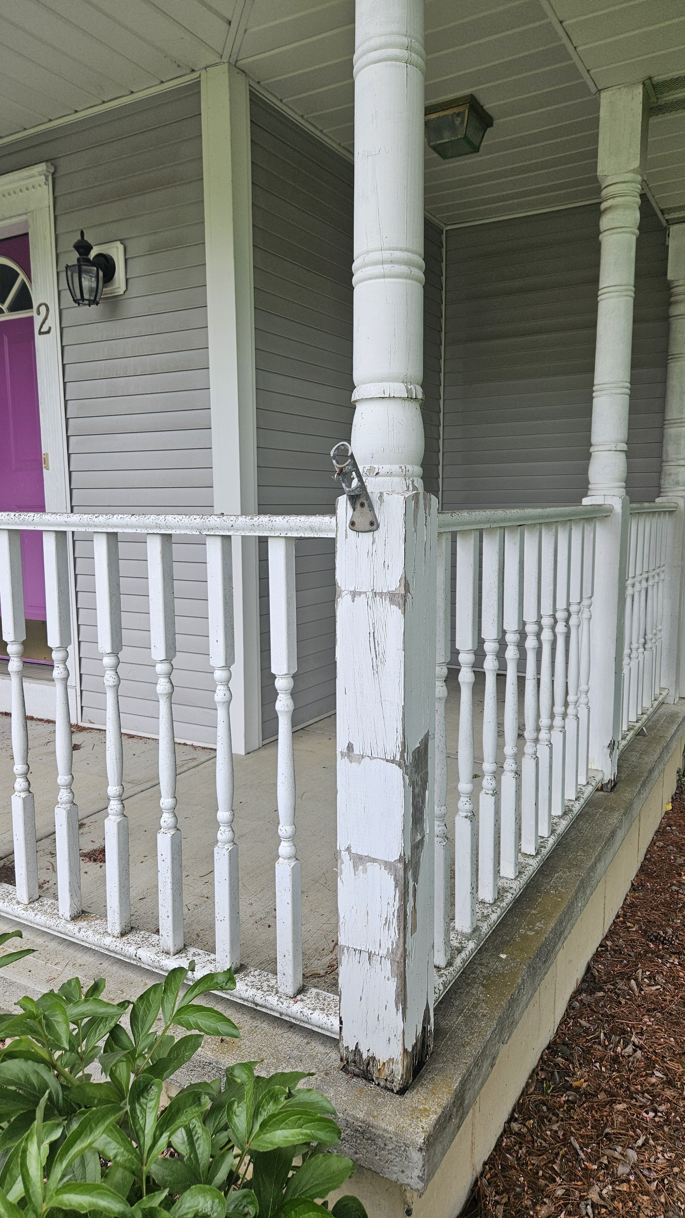 Before: old wood railings and rotted porch posts before a full porch rebuild and railing replacement and exterior repair. 