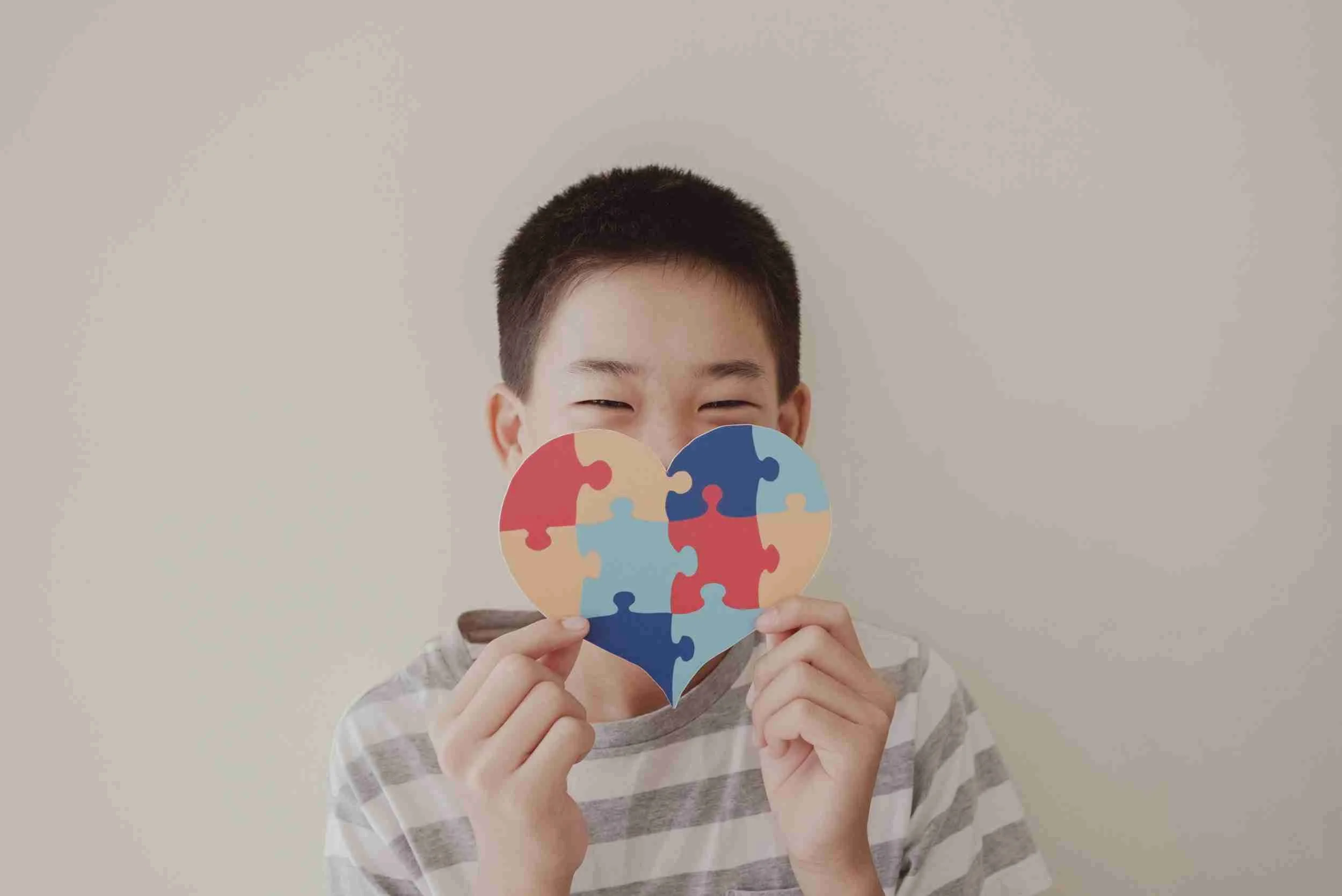Person holding a heart-shaped puzzle piece