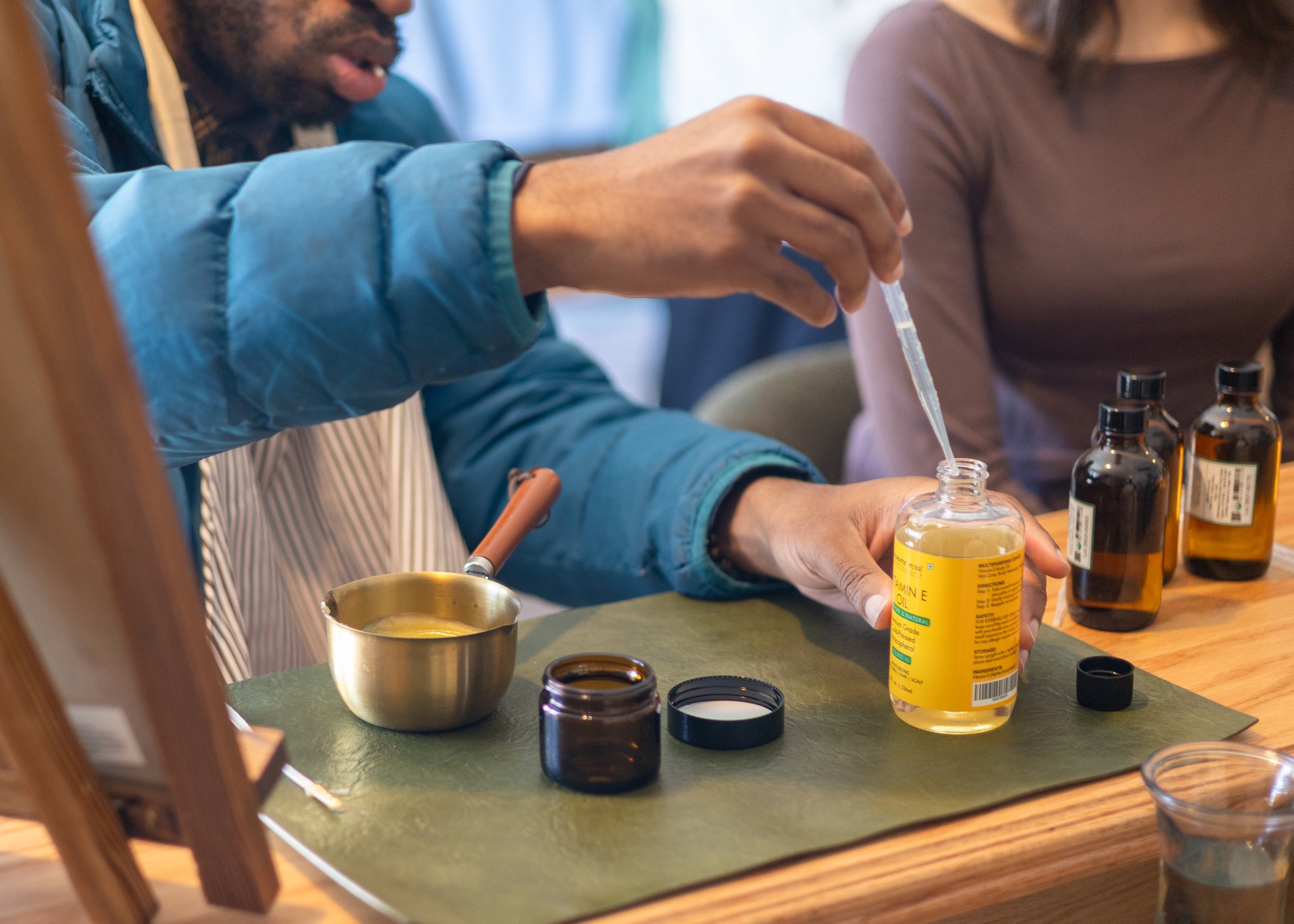 A soft opening customer adds Vitamin E oil to his beeswax/jojoba oil blend.