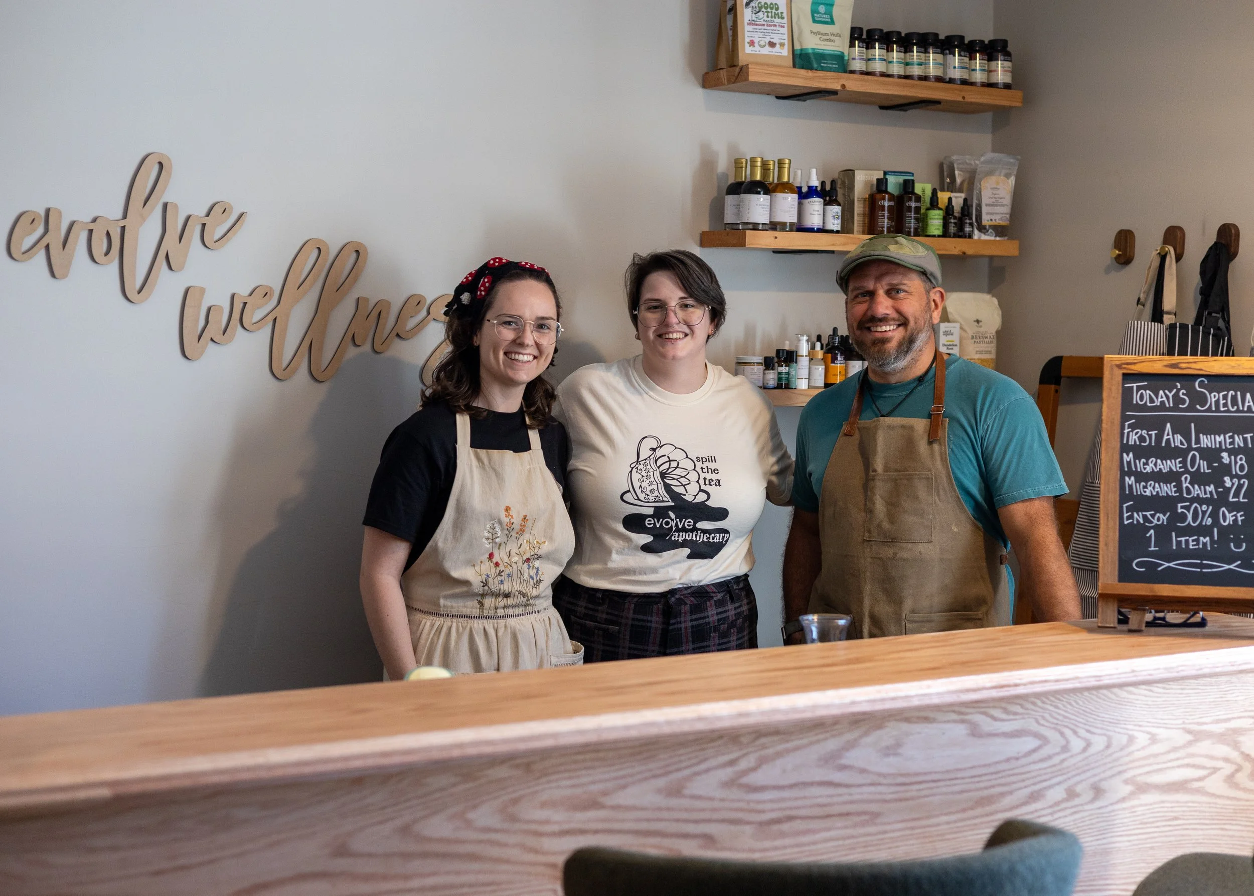 Tyler Mauler, Rebekah Kuper and Charles R. Fisher pose behind the Herbal Bar.