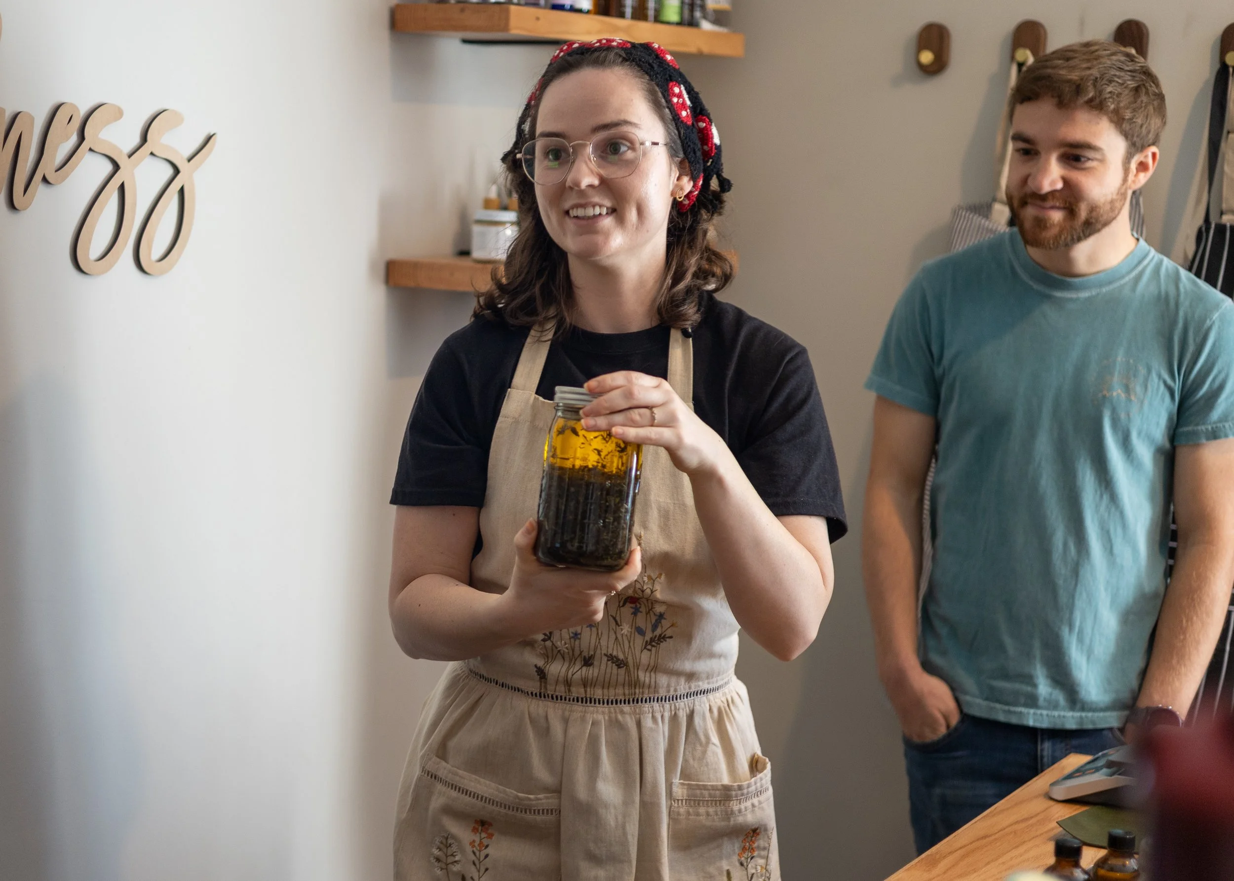 Tyler holding a jar of calendula oil, which will be used in handmade crafts at our grand opening.