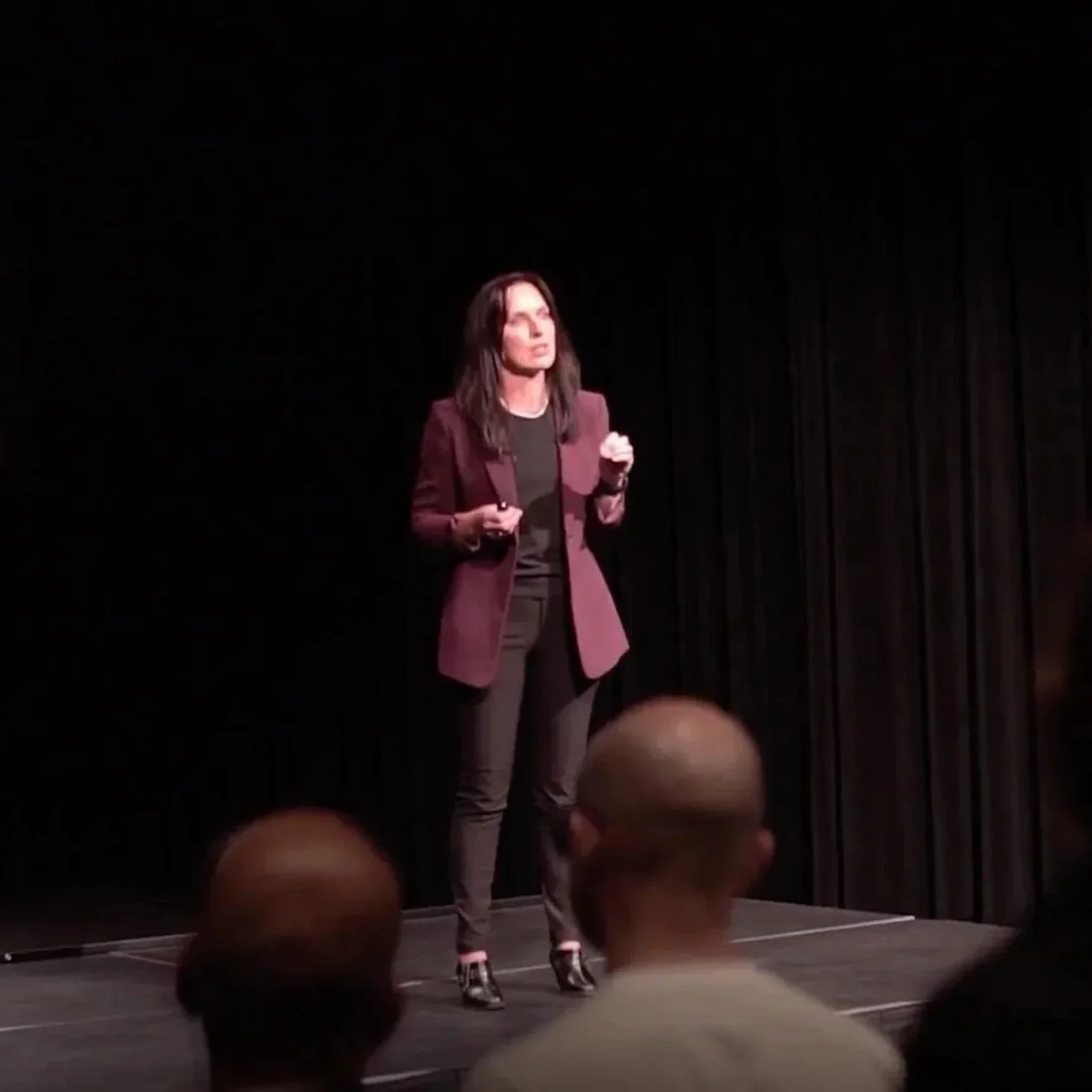 melinda east presenting on stage at a facilitated workshop