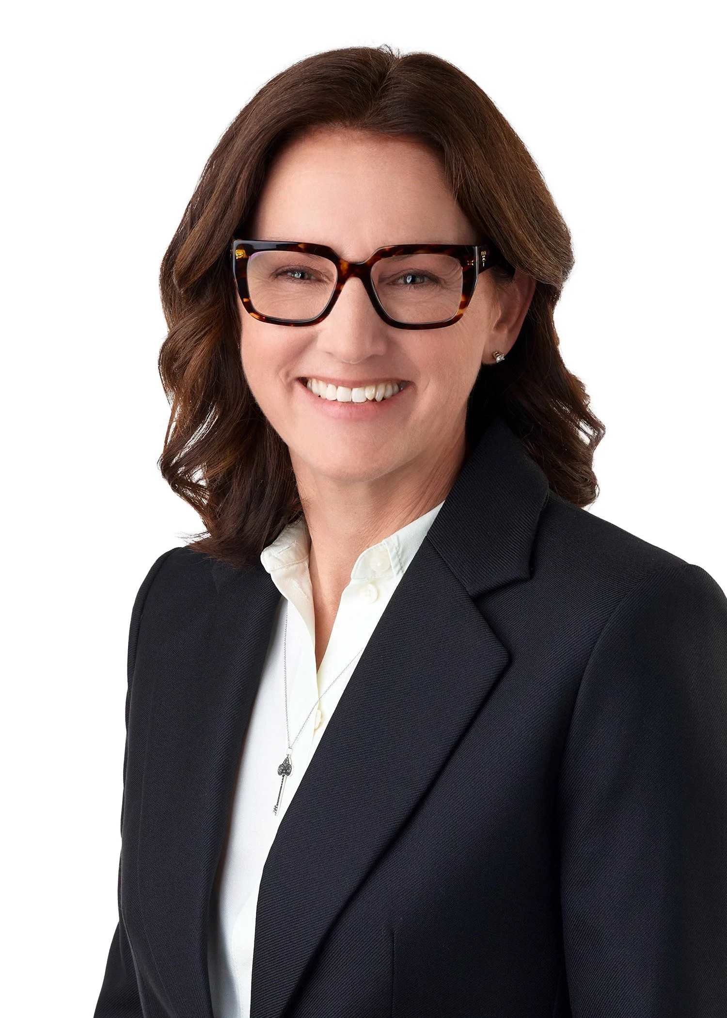 Close-up of a smiling woman with curly hair partially covering her face.
