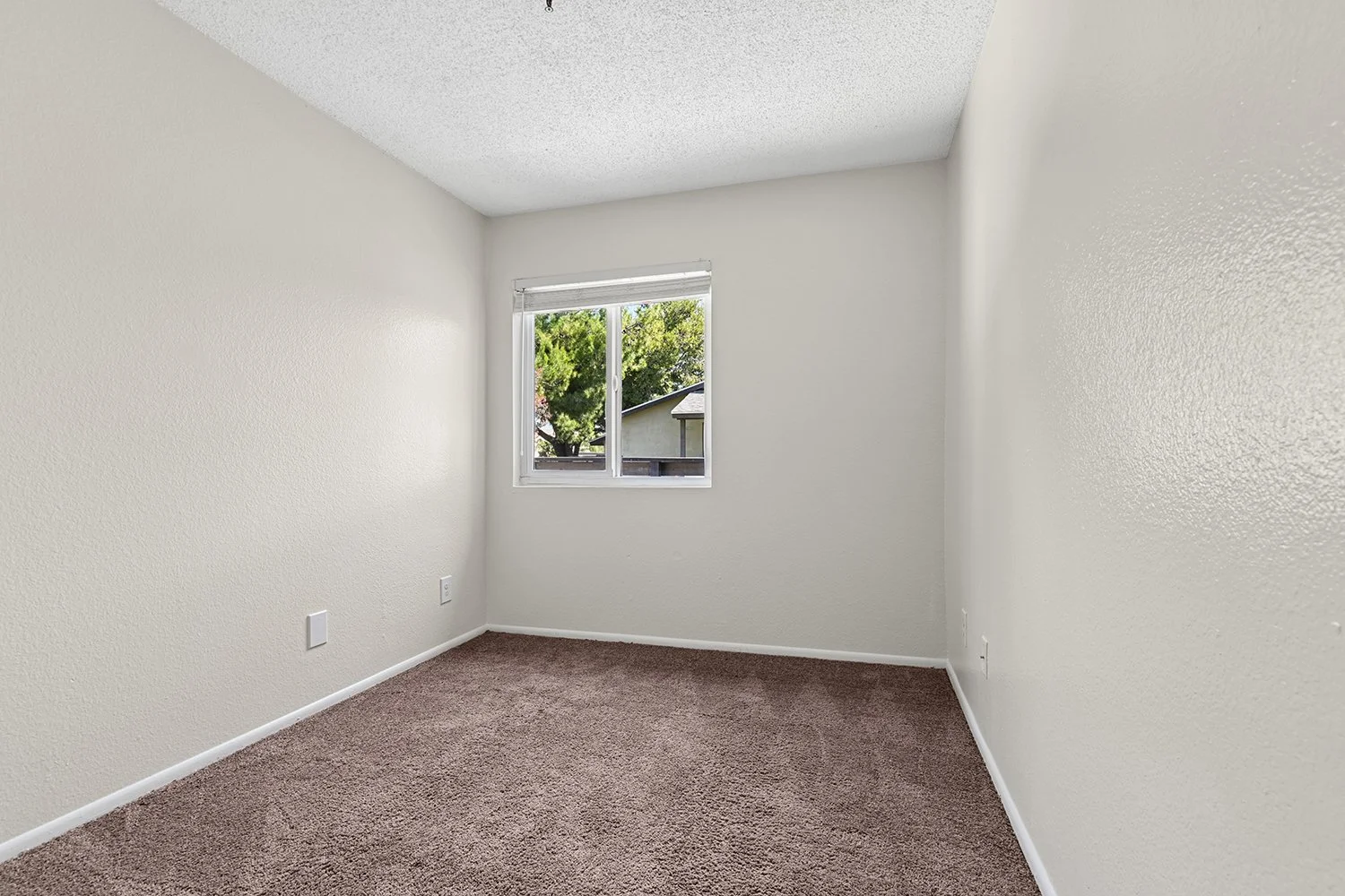 Second bedroom in Citrus Heights 3 Bedroom apartment home with plush carpeted flooring and large window. 