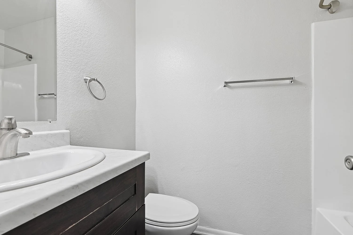 Second bathroom in Citrus Heights 3 Bedroom apartment home with plank flooring, a shower/tub, dark cabinetry and quartz countertops.