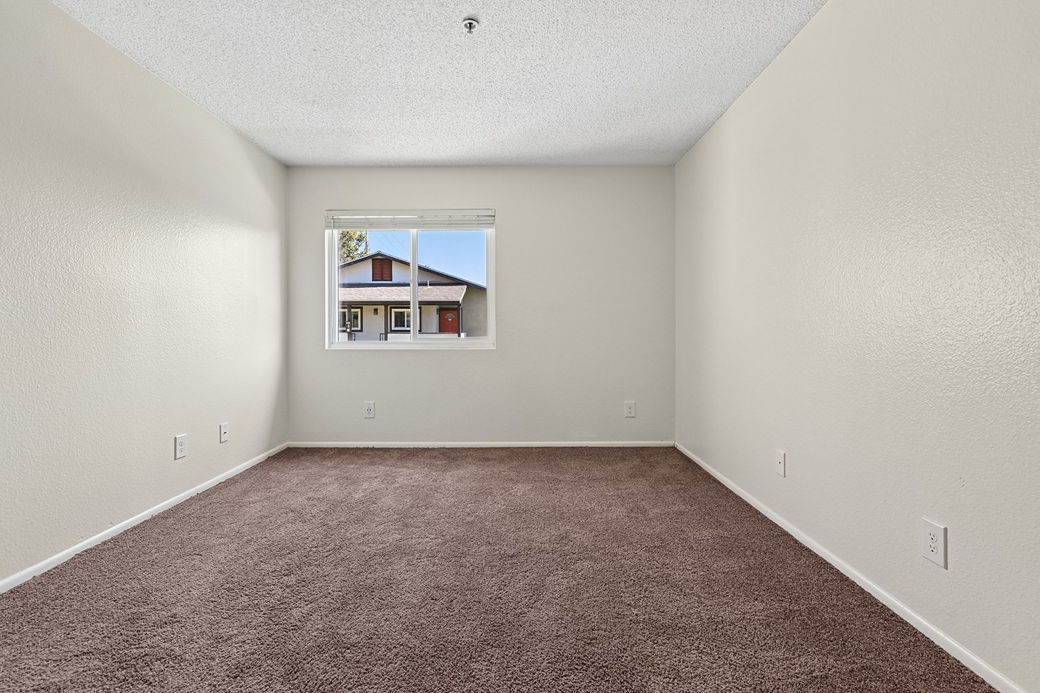 Second bedroom in Citrus Heights 3 Bedroom apartment home with plush carpeted flooring and large window. 