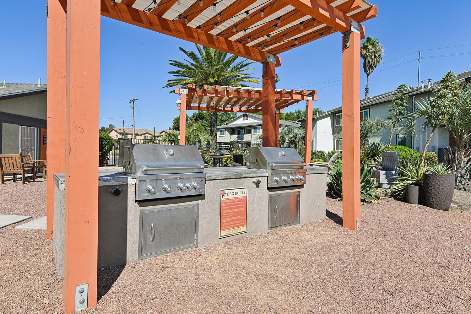 Barbecue grilling station at Citrus Heights under shaded trellis surrounded by park-like landscaping. 