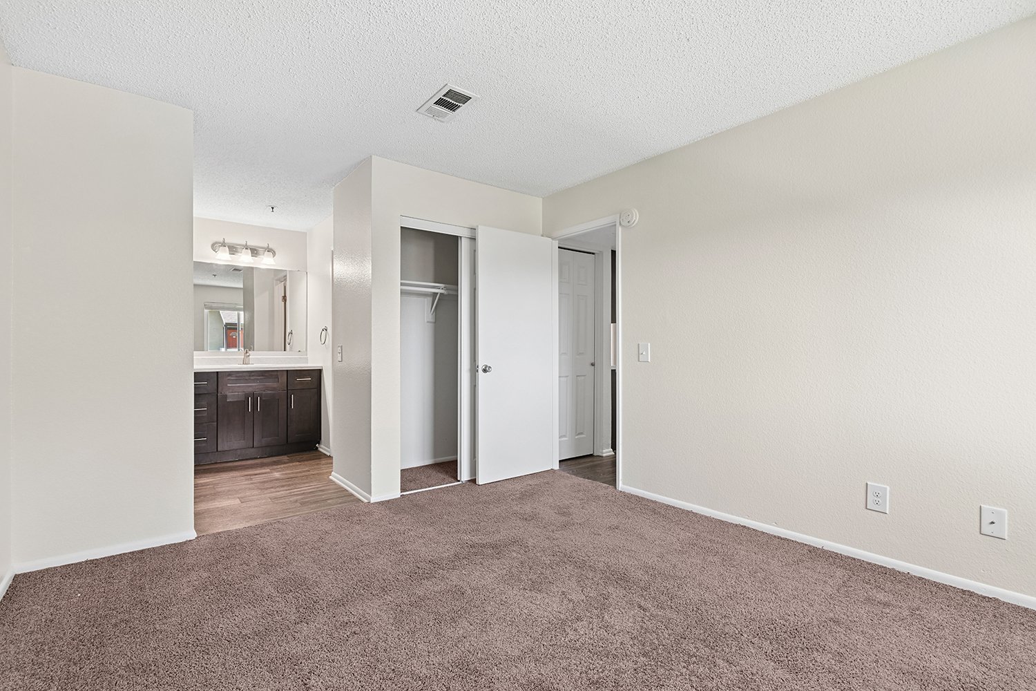 Oversized primary bedroom in Citrus Heights 3-Bedroom apartment home with plush carpeted flooring, private bathroom and large windows allowing for gorgeous natural lighting. 