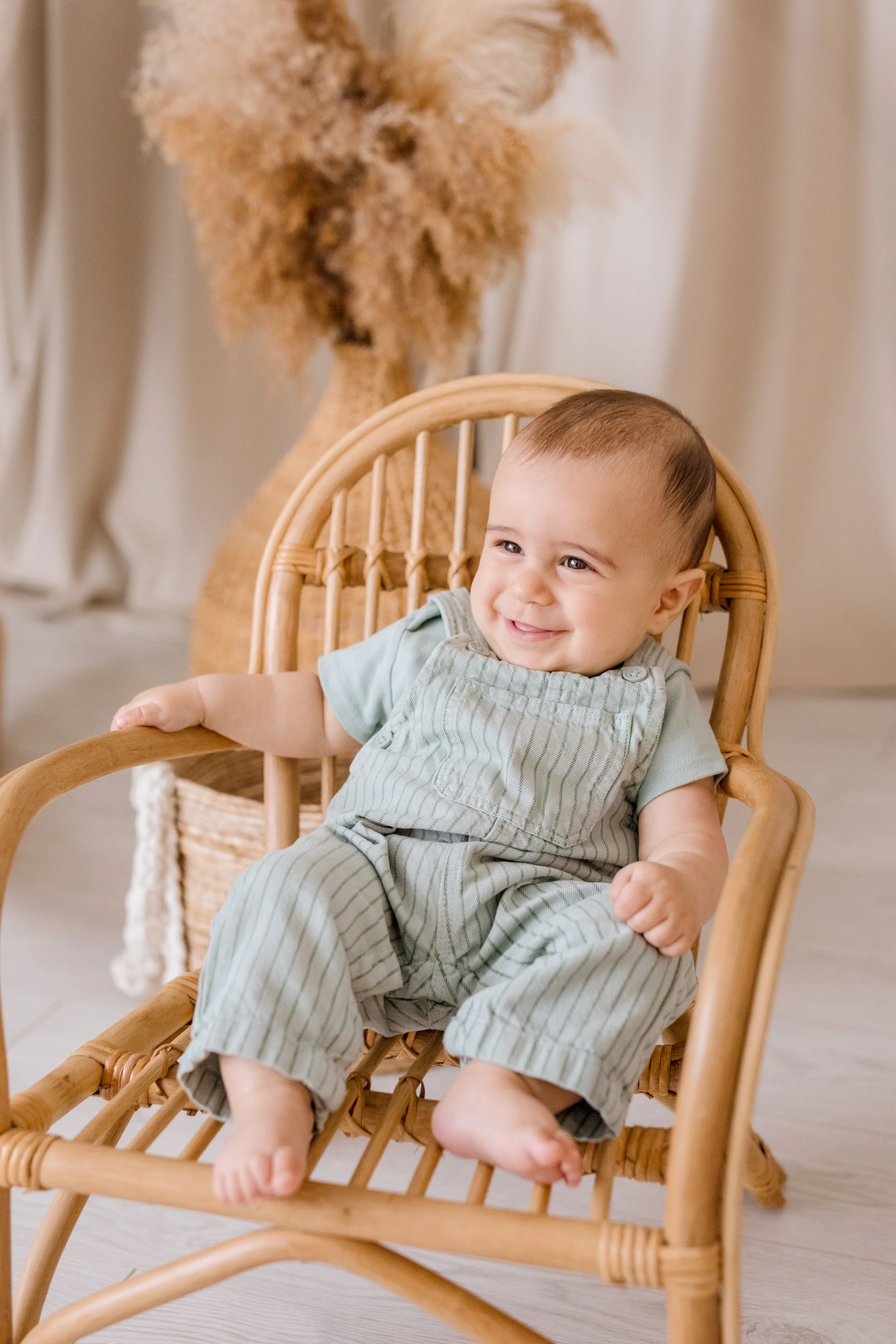 Six-month milestone session of baby boy alone in studio, showing adorable expressions