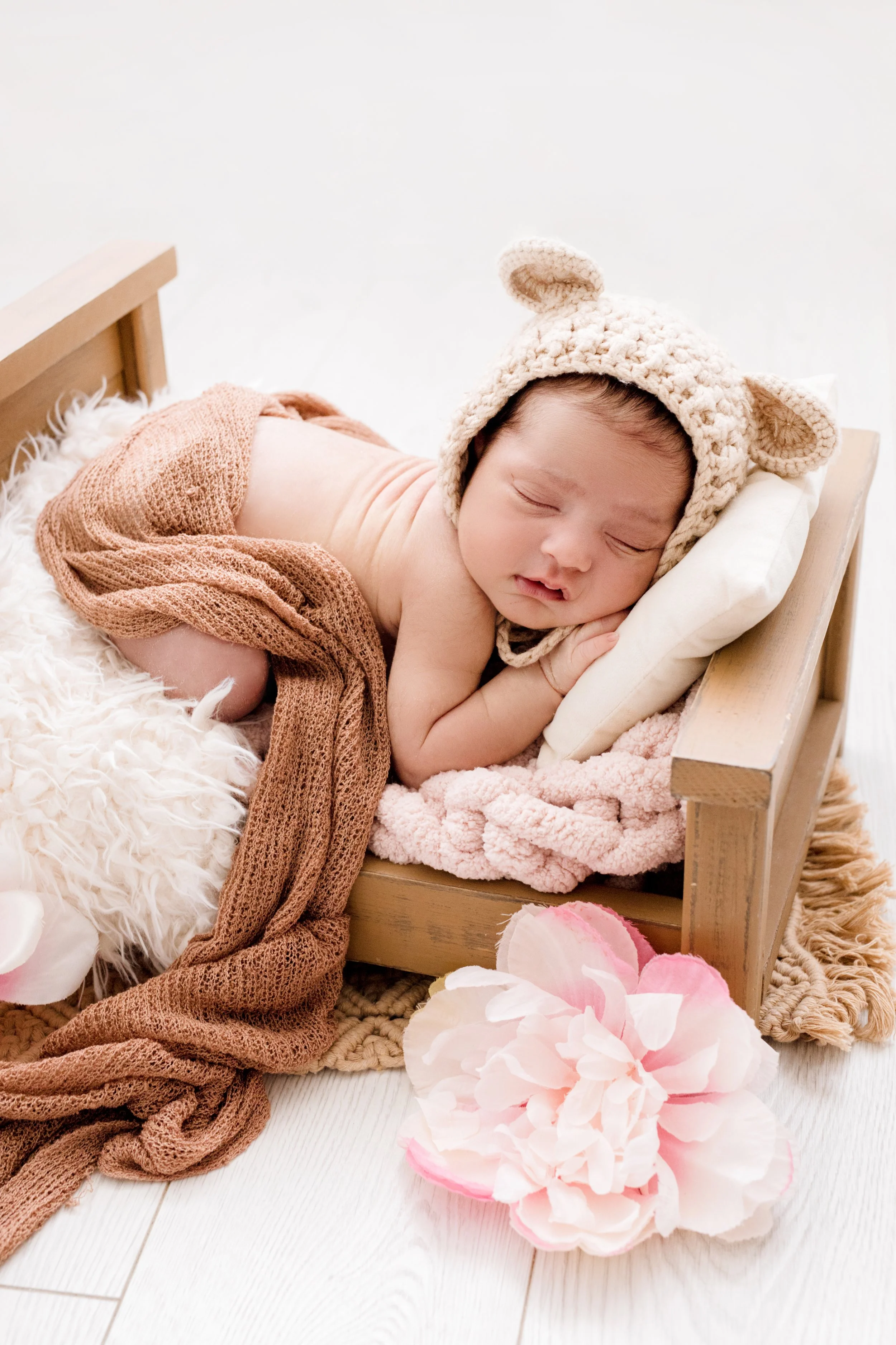 Newborn girl in tiny bed setup during luxury photography session in Mississauga