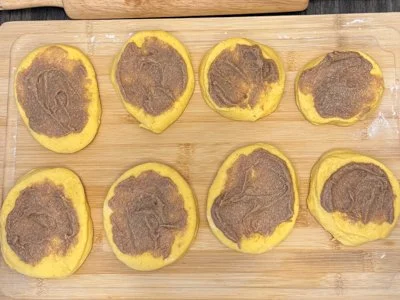 pumpkin bread dough cut into circles with sweet pumpkin spice butter spread on top