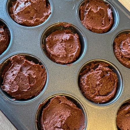 brownie batter spooned into a muffin pan