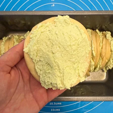 sour cream and onion cream cheese spread on a dough circle