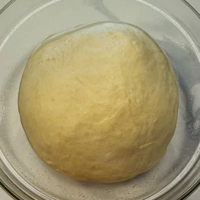 a ball of pull apart bread dough after the first rise