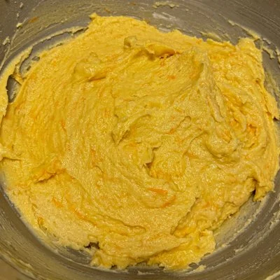 carrot and orange cake batter in a metal mixing bowl
