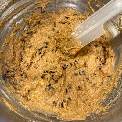 peanut butter, date, and banana muffin batter in a metal mixing bowl