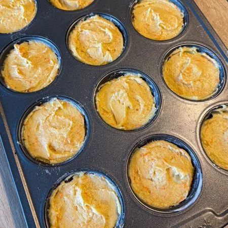 cupcake pan filled with carrot and orange cake pan