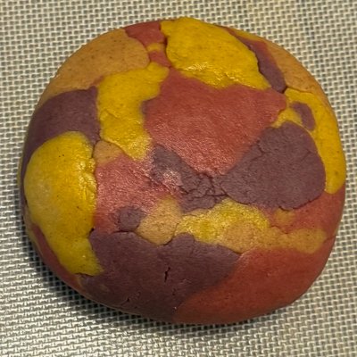 a ball of multi-colored (brown, yellow, purple, and red) cookie dough