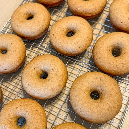 baked apple cider donuts on a wire cooling rack