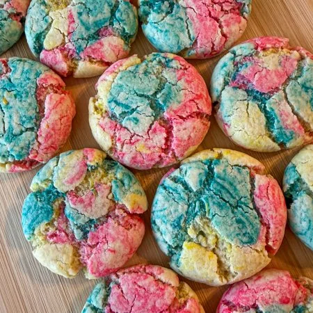 close up of tie dye cookies on a wooden cutting board