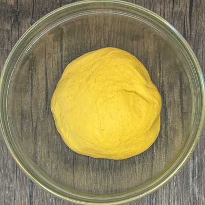 pumpkin bread dough in a clear bowl before its first rise