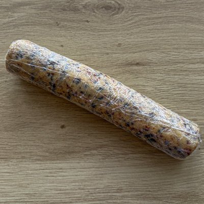 cherry chocolate almond cookie dough rolled into a long cylinder wrapped in plastic wrap