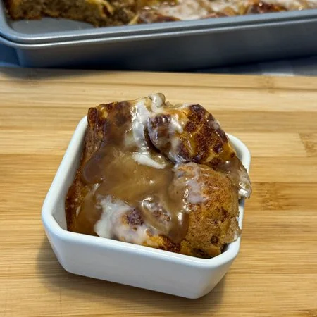 banana bread cinnamon roll bake in a square bowl with a pan in the background