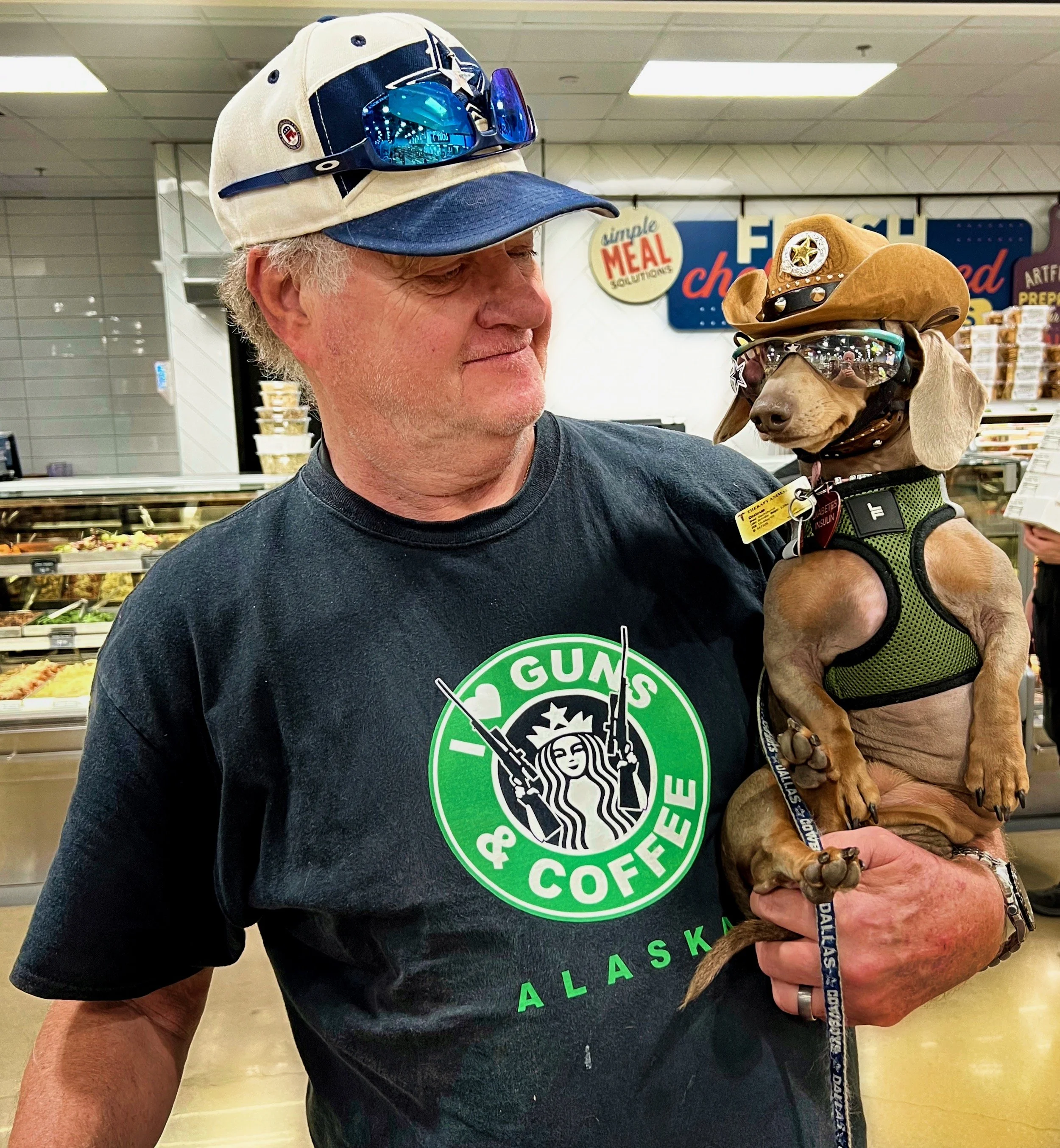  " The Real Boss "  Proud dog owner and his uniquely dressed dachshund share a moment.