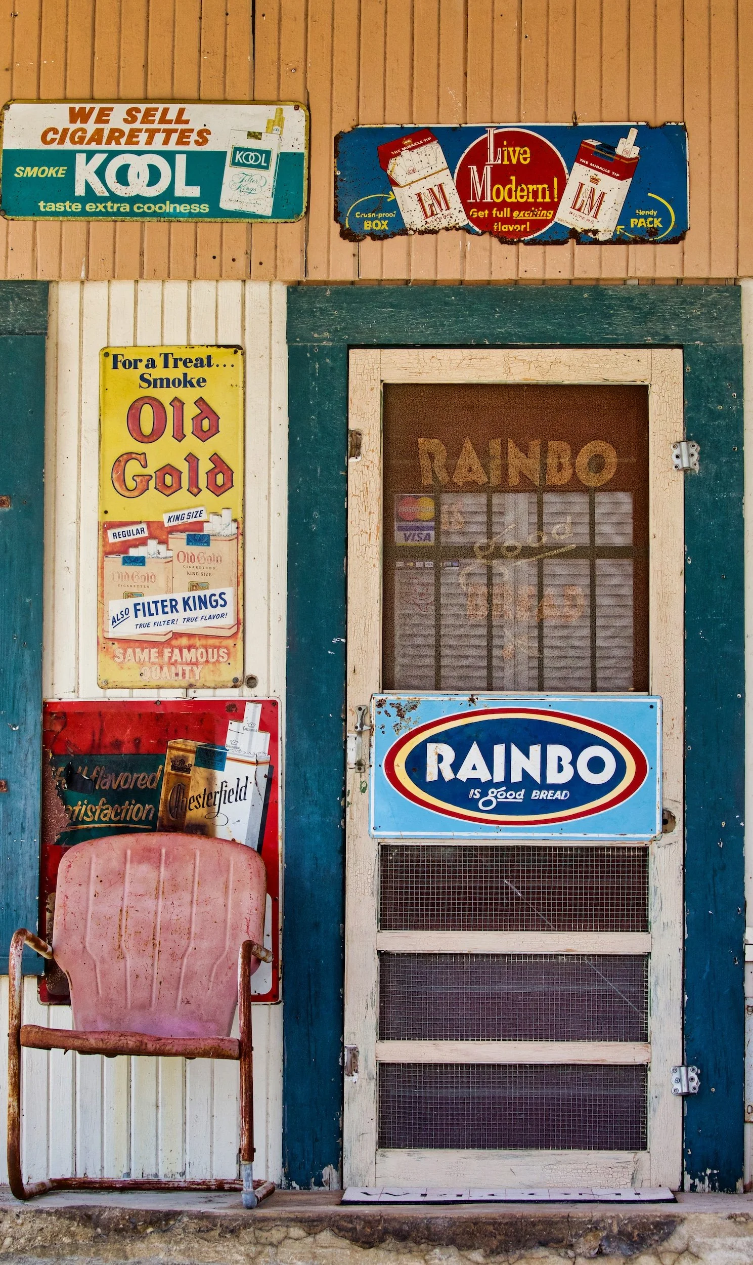 "Yesterday's  Chair".  A faded chair waits beneath vintage signs outside a forgotten country store