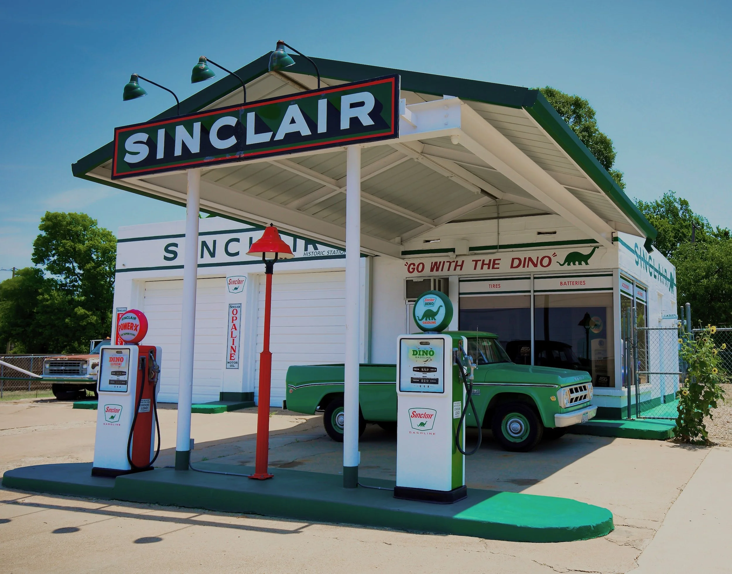  " Go with the DINO "  Old Sinclair Gas Station in Fort Worth, Texas. Featuring old gas pumps, and  classic trucks.