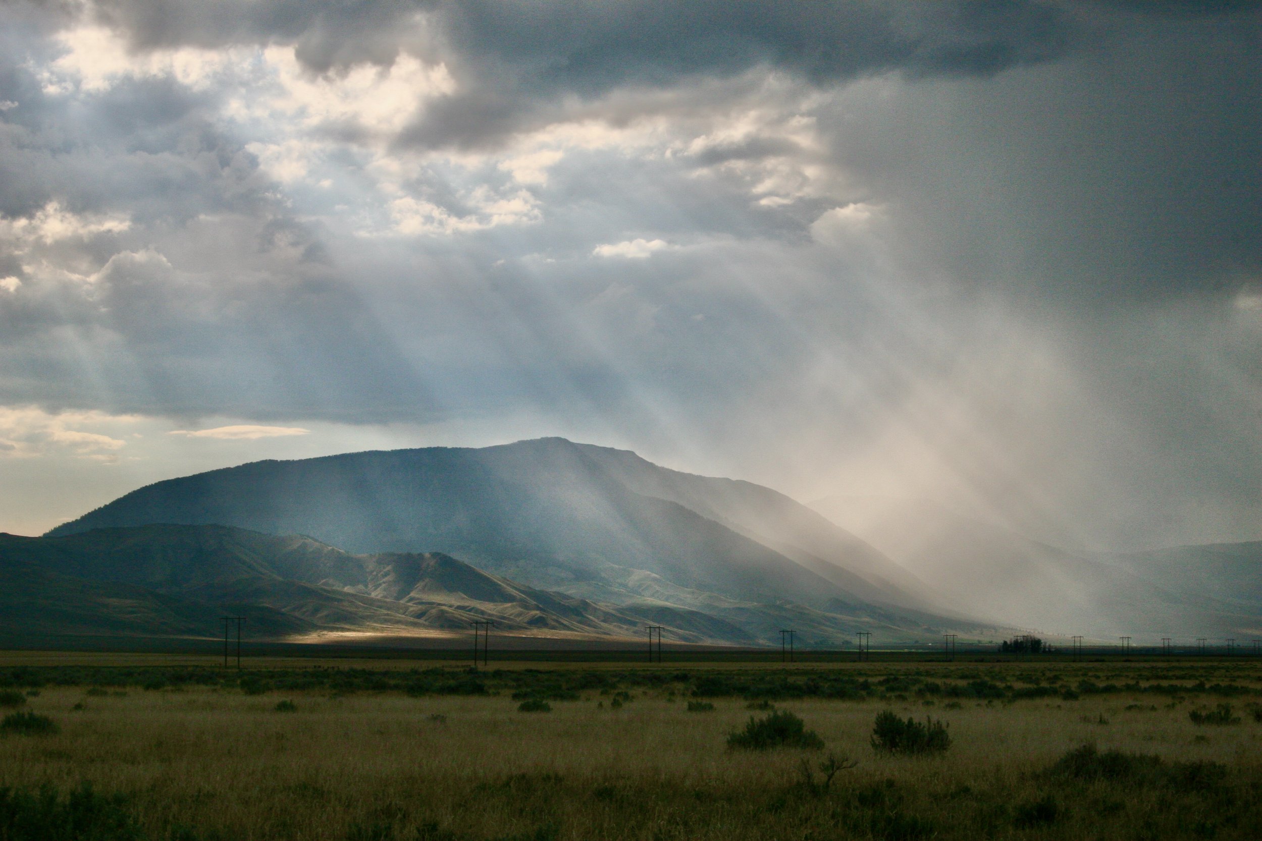 " Rain Curtain "  Mountain storm in the Rocky Mountains, sunlight coming through the storm clouds, sweeping needed rain