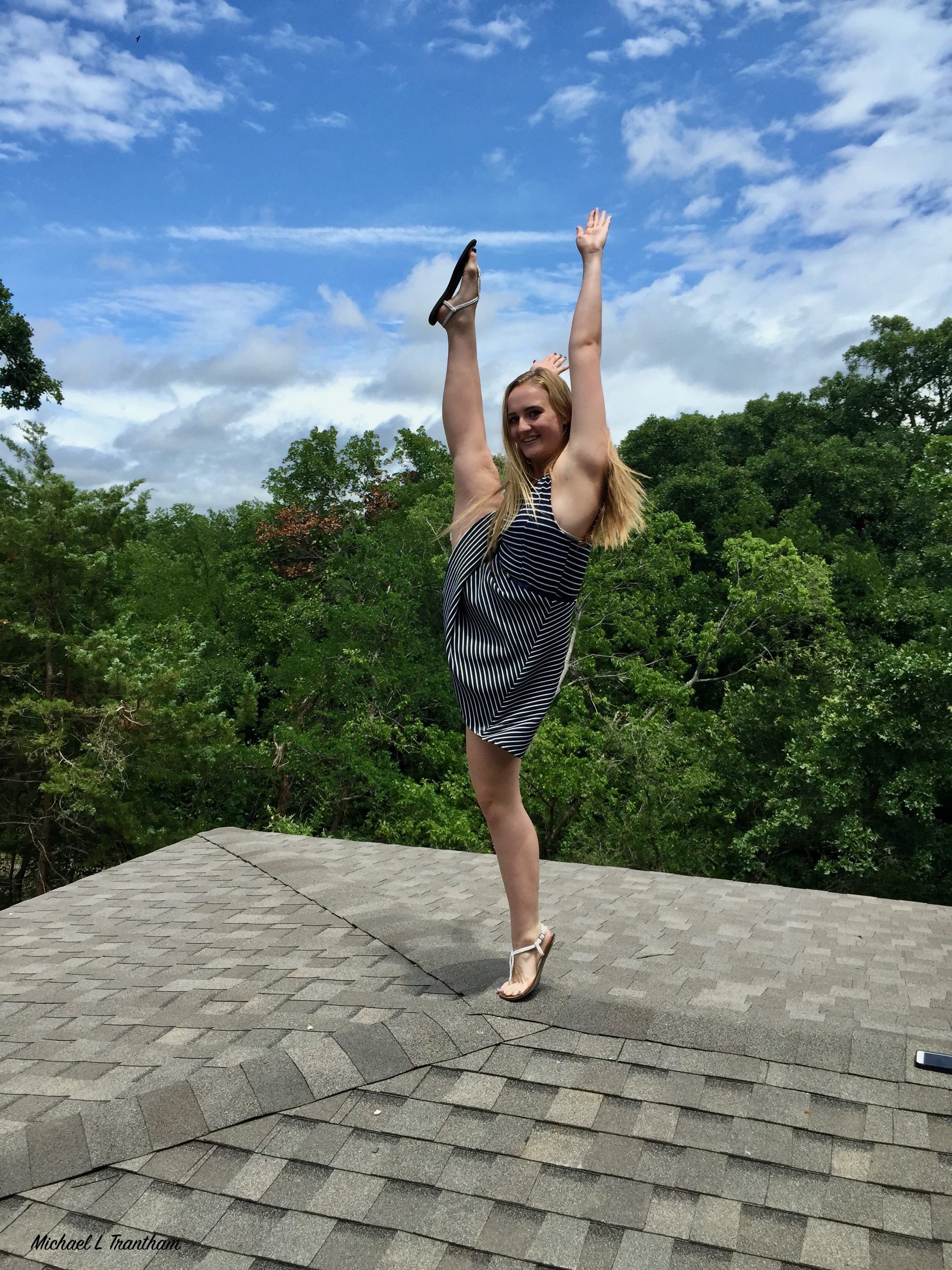 " Defying Gravity "  Young woman performing a high kick against a blue sky, capturing balance, flexibility, and joy.