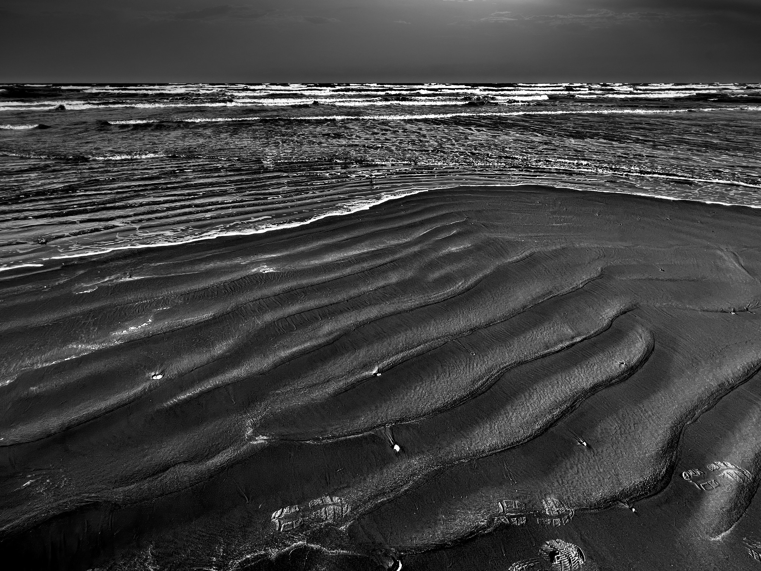  " Sand Serpents " Wave shaped sand patterns along the Texas Gulf Coast in black-and-white photography.
