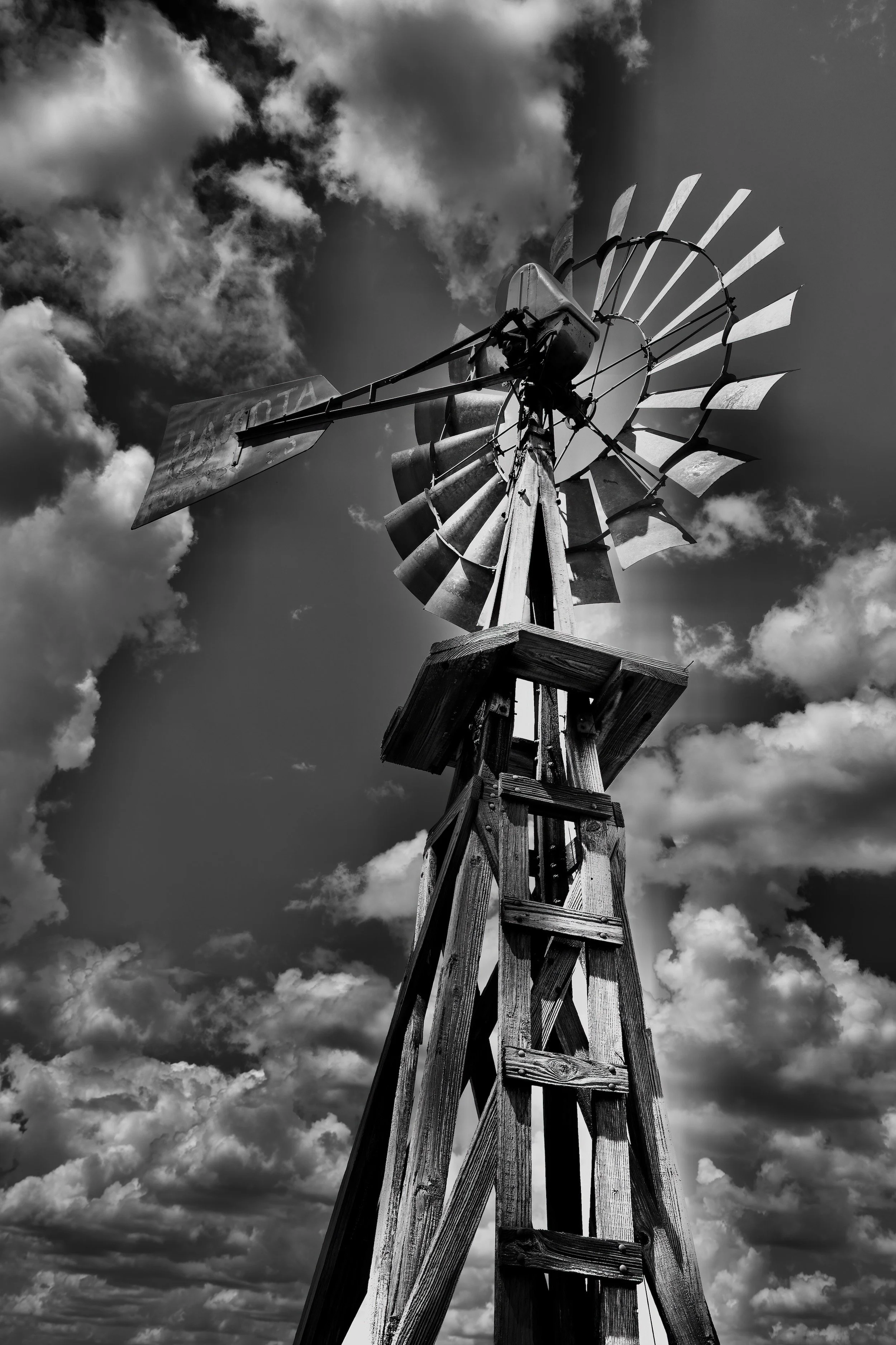 " Sky Harvester " Historic Texas windmill standing beneath dramatic clouds in black-and-white fine art photography.