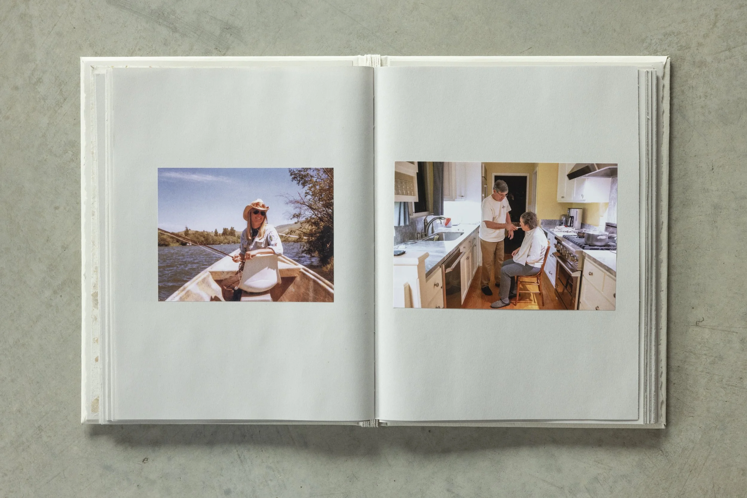 Open scrapbook showing two photographs; one of a woman in a boat on a river, and the other of a man and woman in a kitchen.