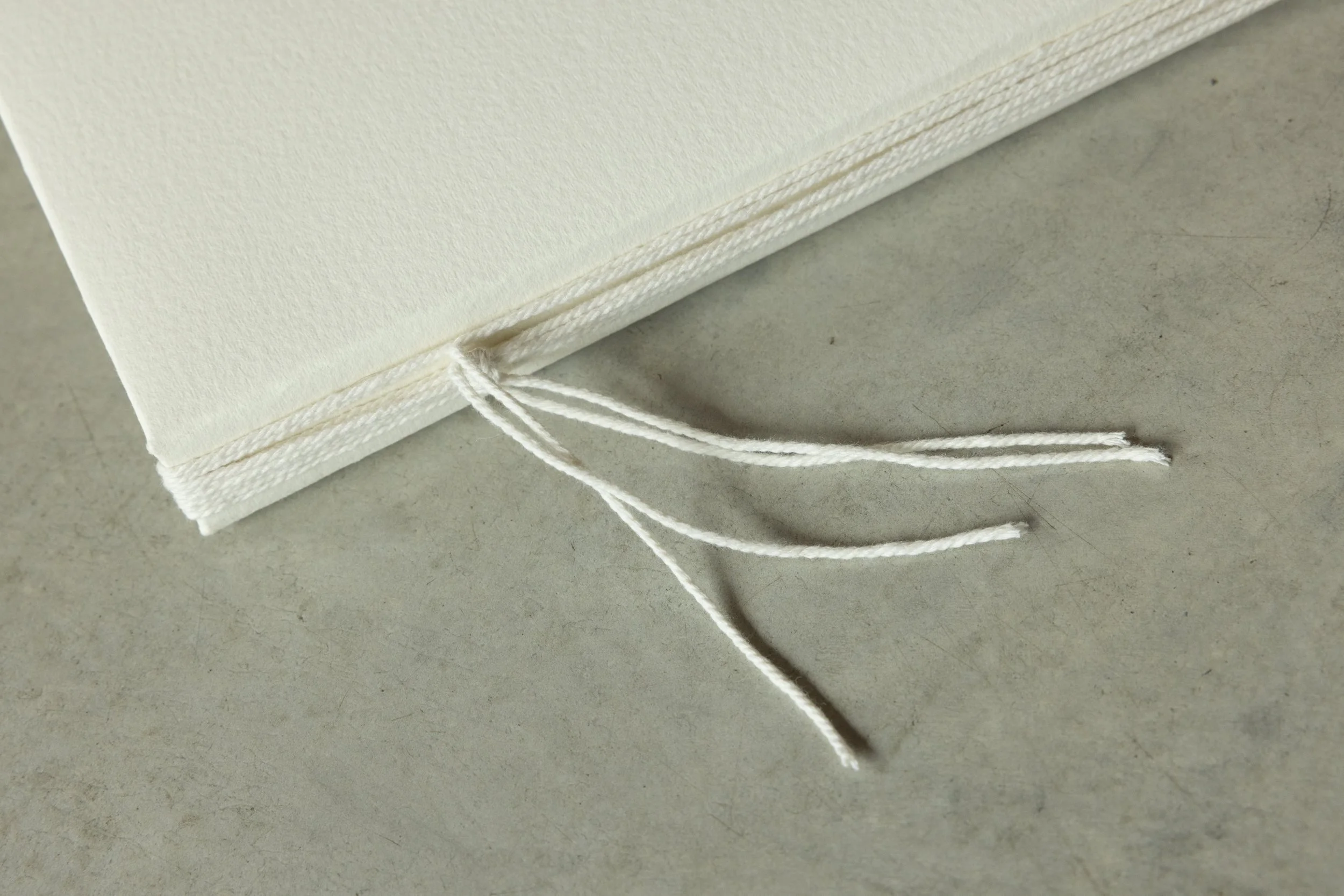 Close-up of a wrapped package with white string on a concrete surface.