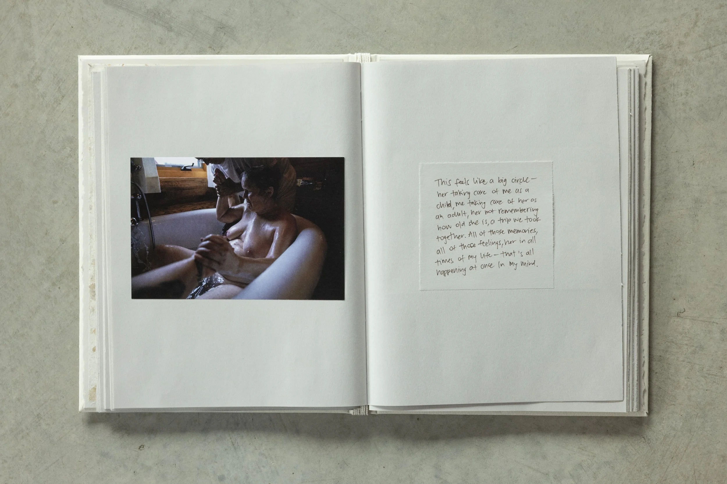 A photo of a woman relaxing in a bathtub, with a handwritten note on a piece of paper next to the photo containing a personal message.